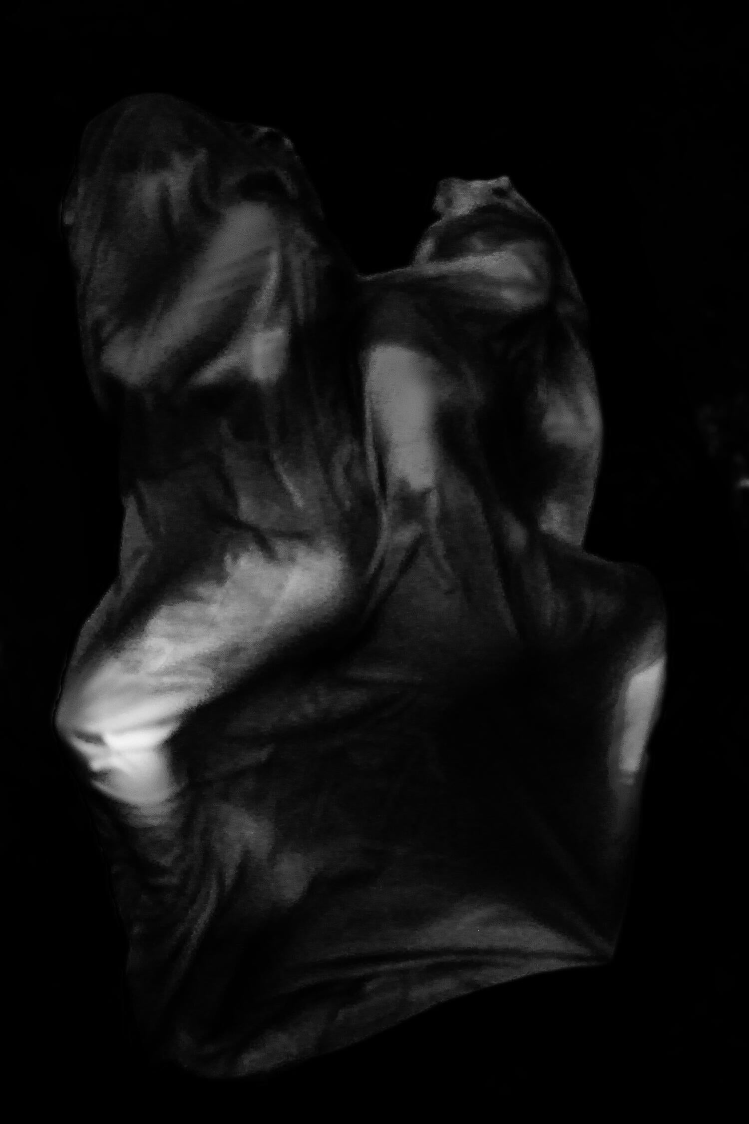 Two figures draped in fabric facing away from each other.