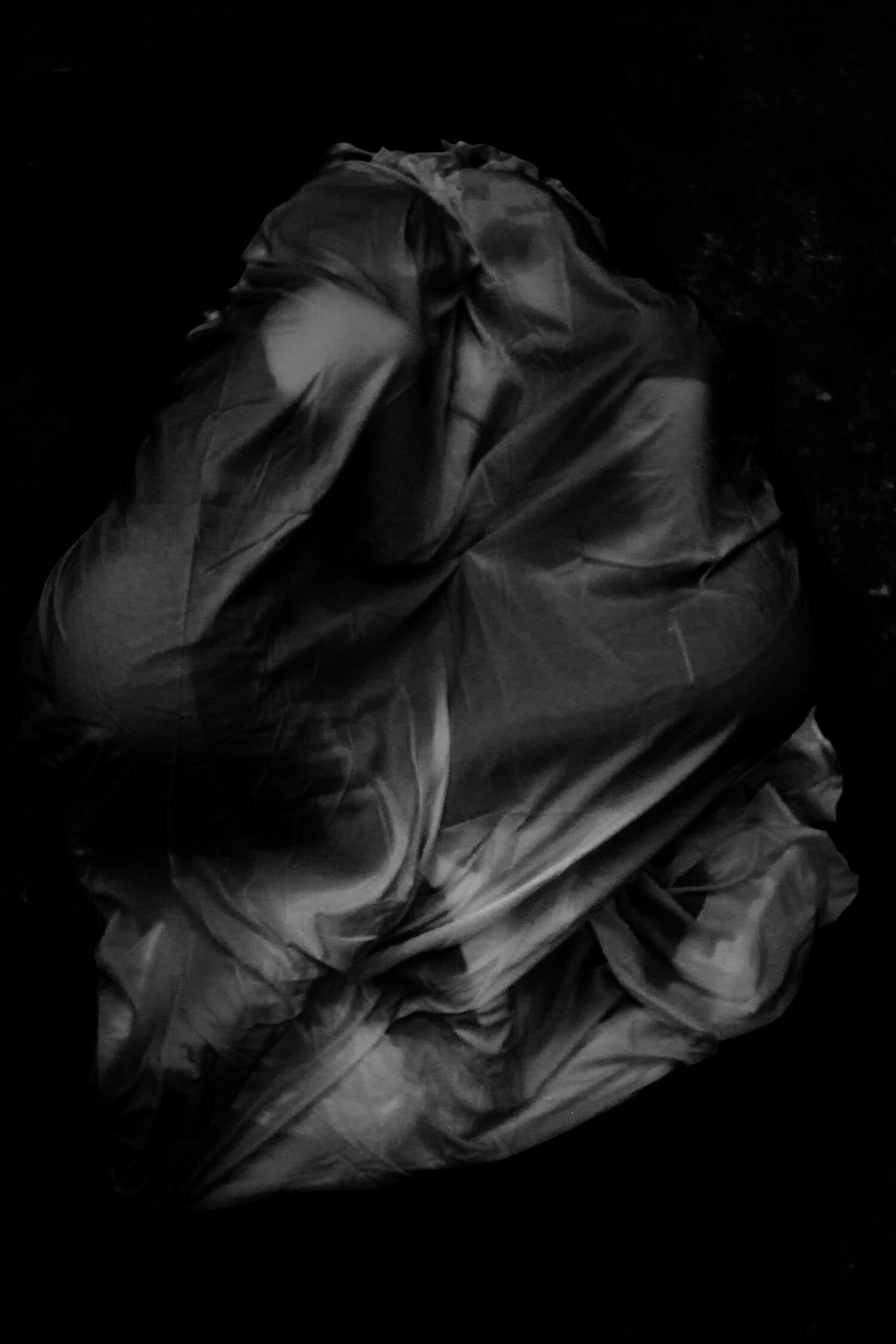 Two figures draped in fabric facing towards each other.
