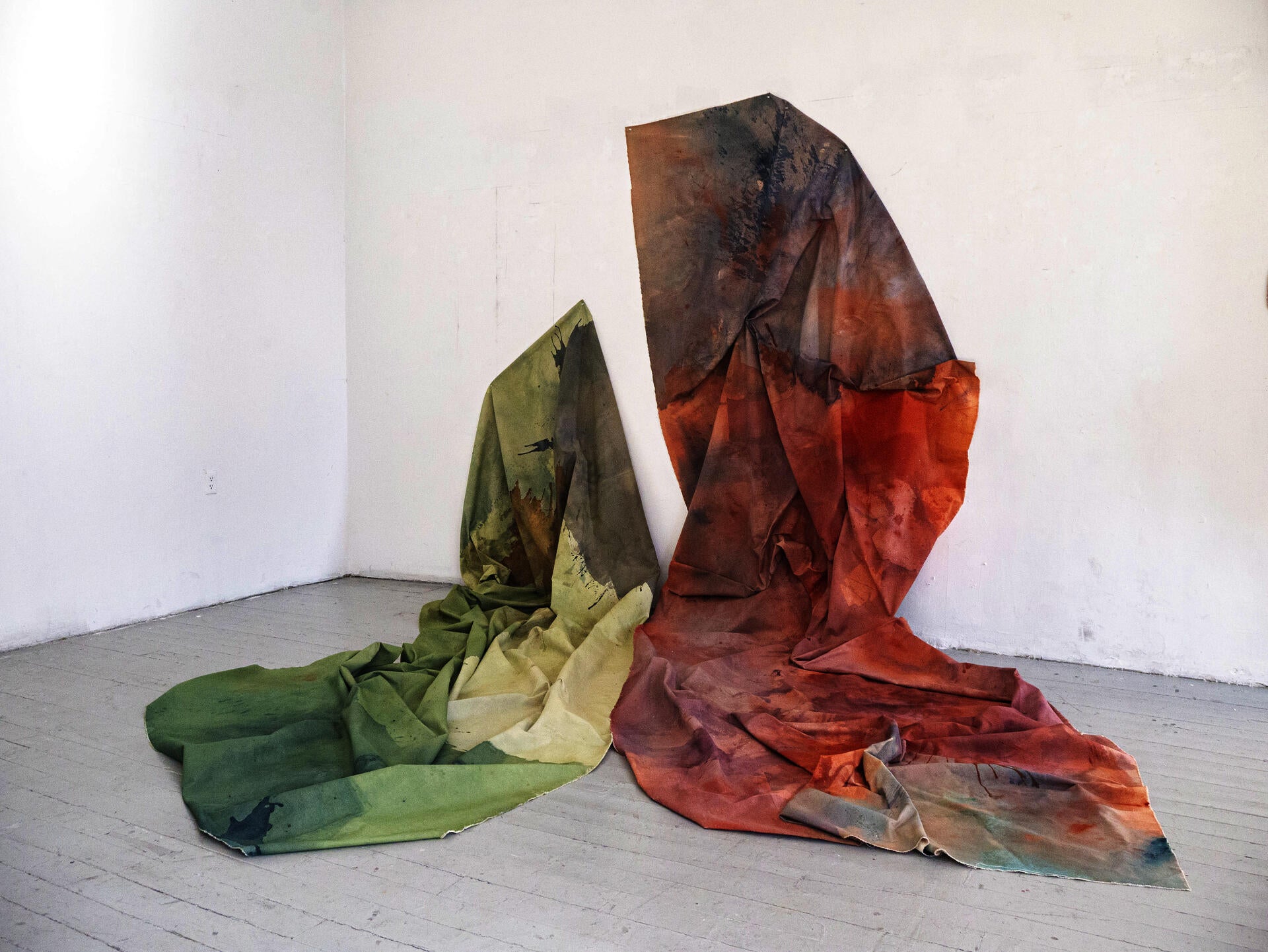 Large folded canvas, gathered and hand sewn together like fabric pouring from partially up the wall to the floor abstracting in the shape of a butterfly.