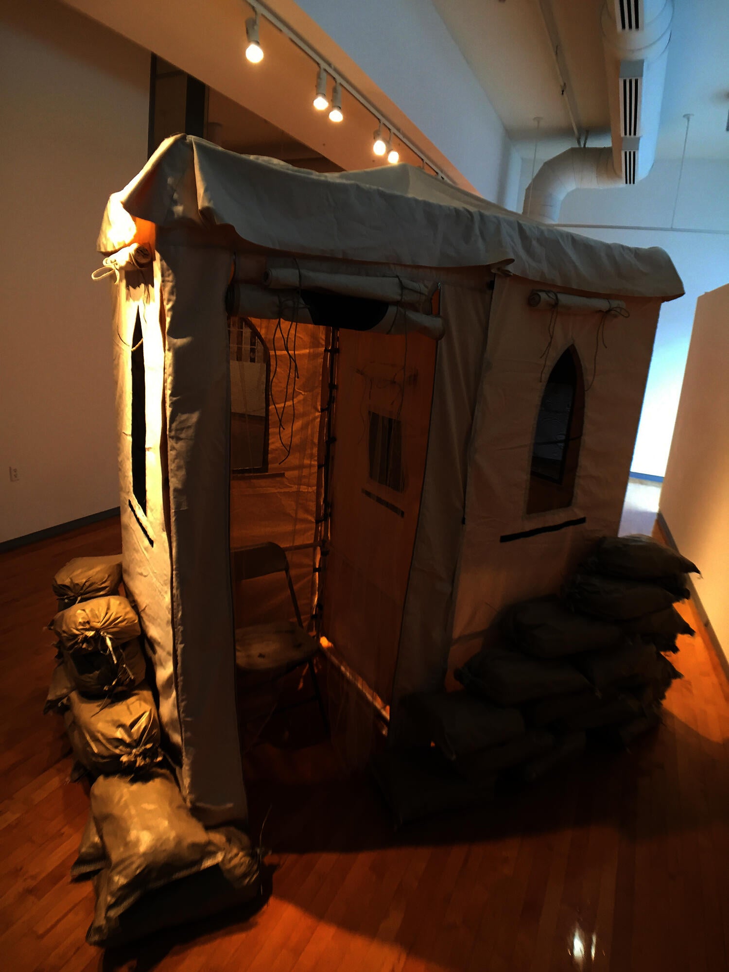 Free Advice, a Chaplain’s Vice is a 9-foot-tall raw canvas-colored tent with arched screened windows reminiscent of hot weather in the desert.
