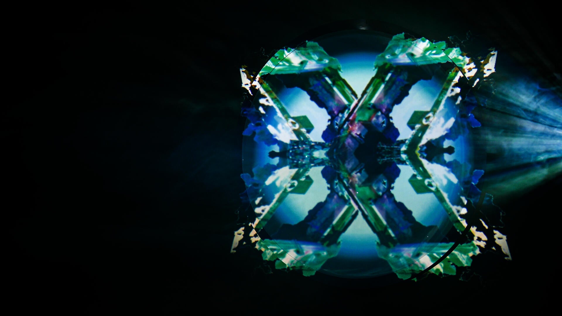 Detail image of large acrylic dome with a photogram animation projected on it and a beam of fog and light obscuring it.