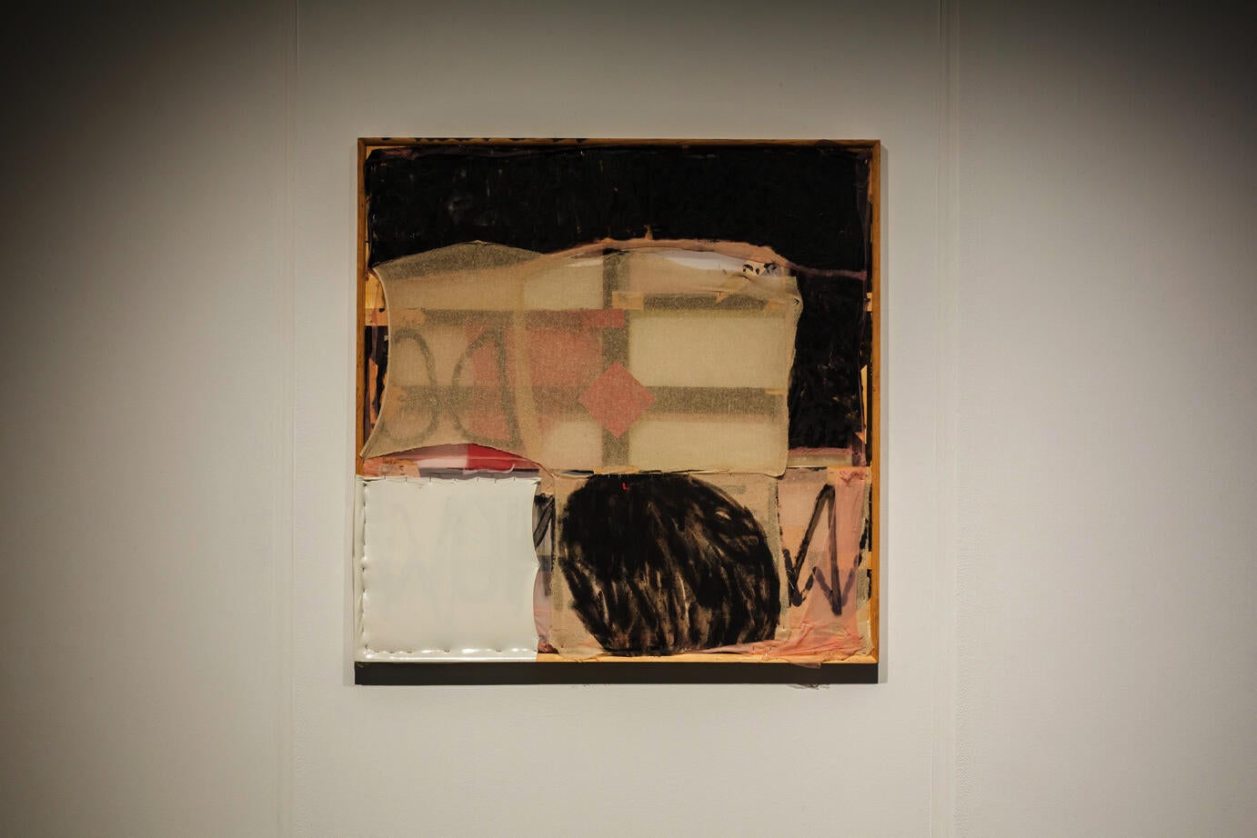 square mixed media artwork hanging on a white wall