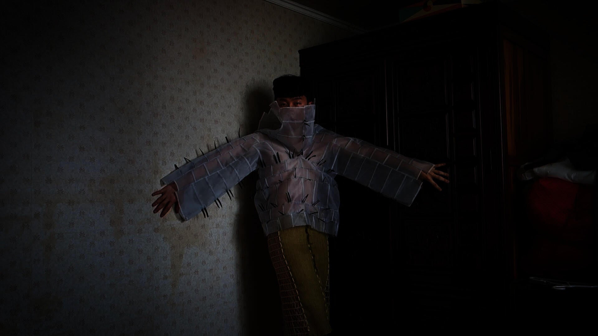Model poses in a dimly lit corner wearing a shirt made of translucent white squares and yellow pants.
