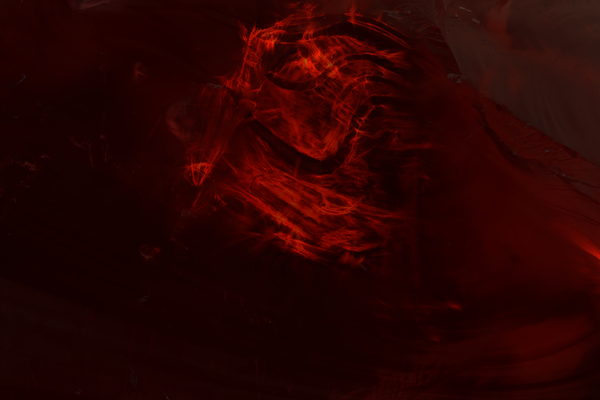 Close-up image of a red gem, with swirling patterns of light.
