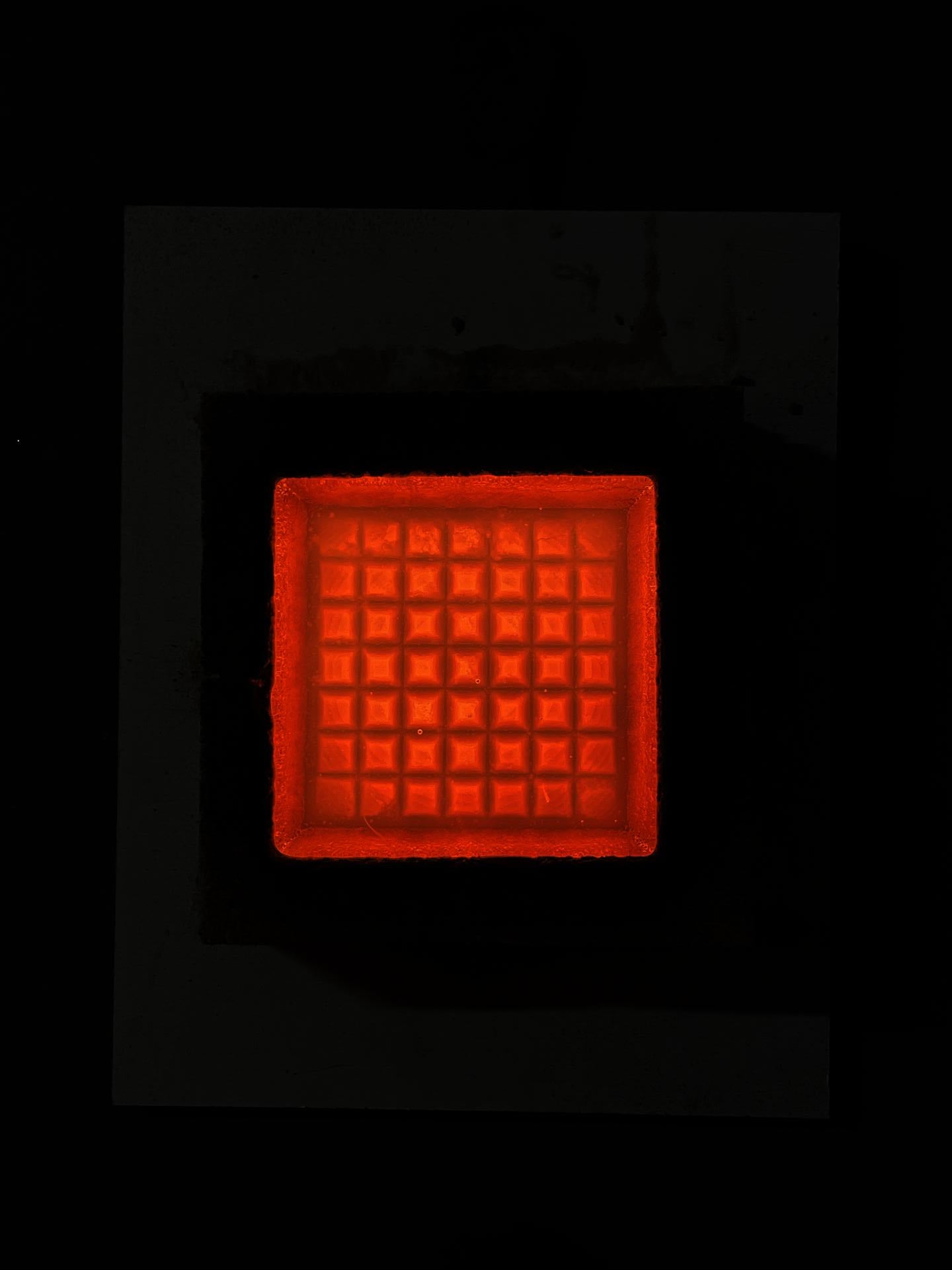 Molten glass poured into an optical grid mold.
