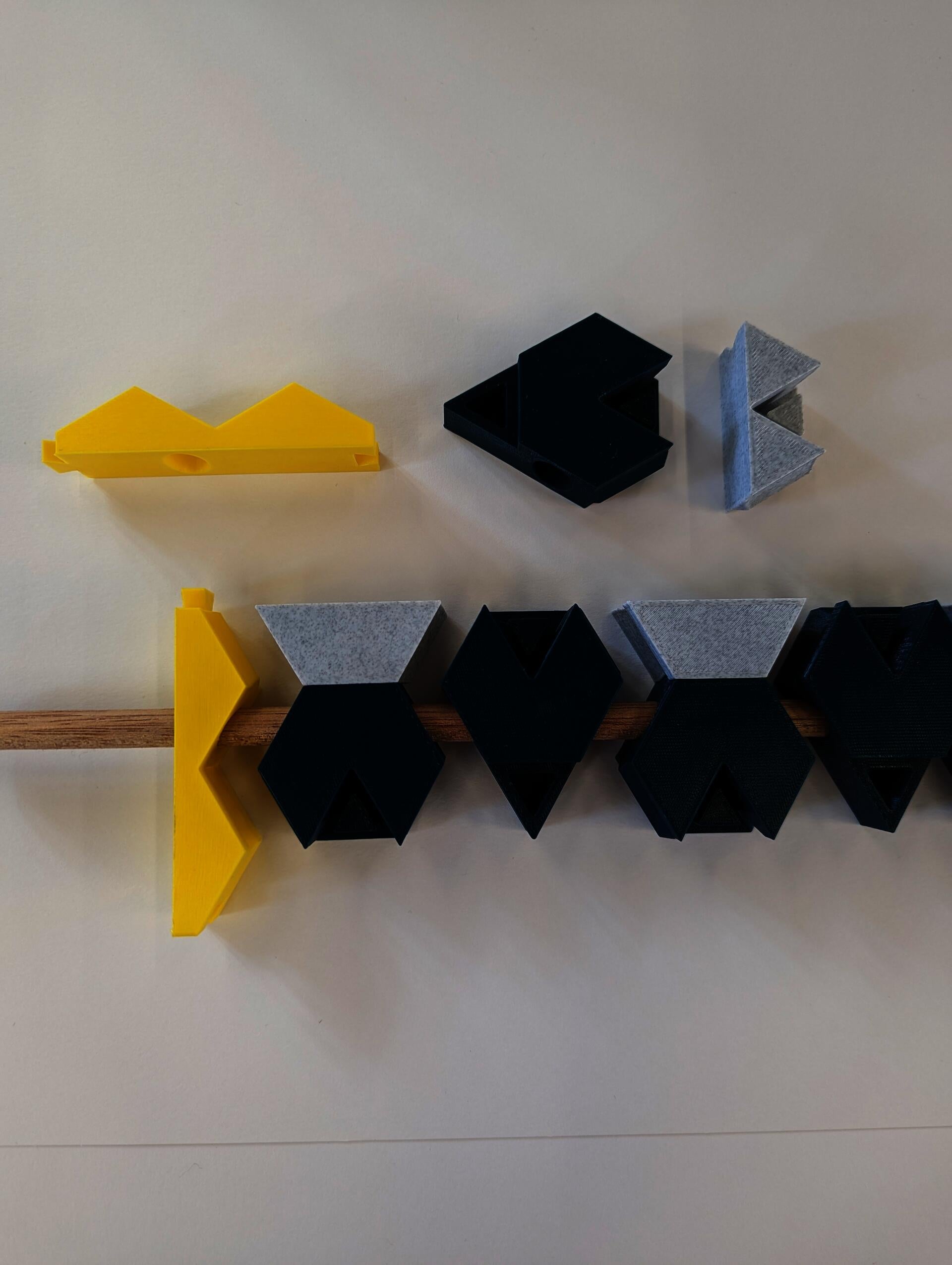 Three hexagon based shapes interlock so as to allow a wooden towel to pass through.