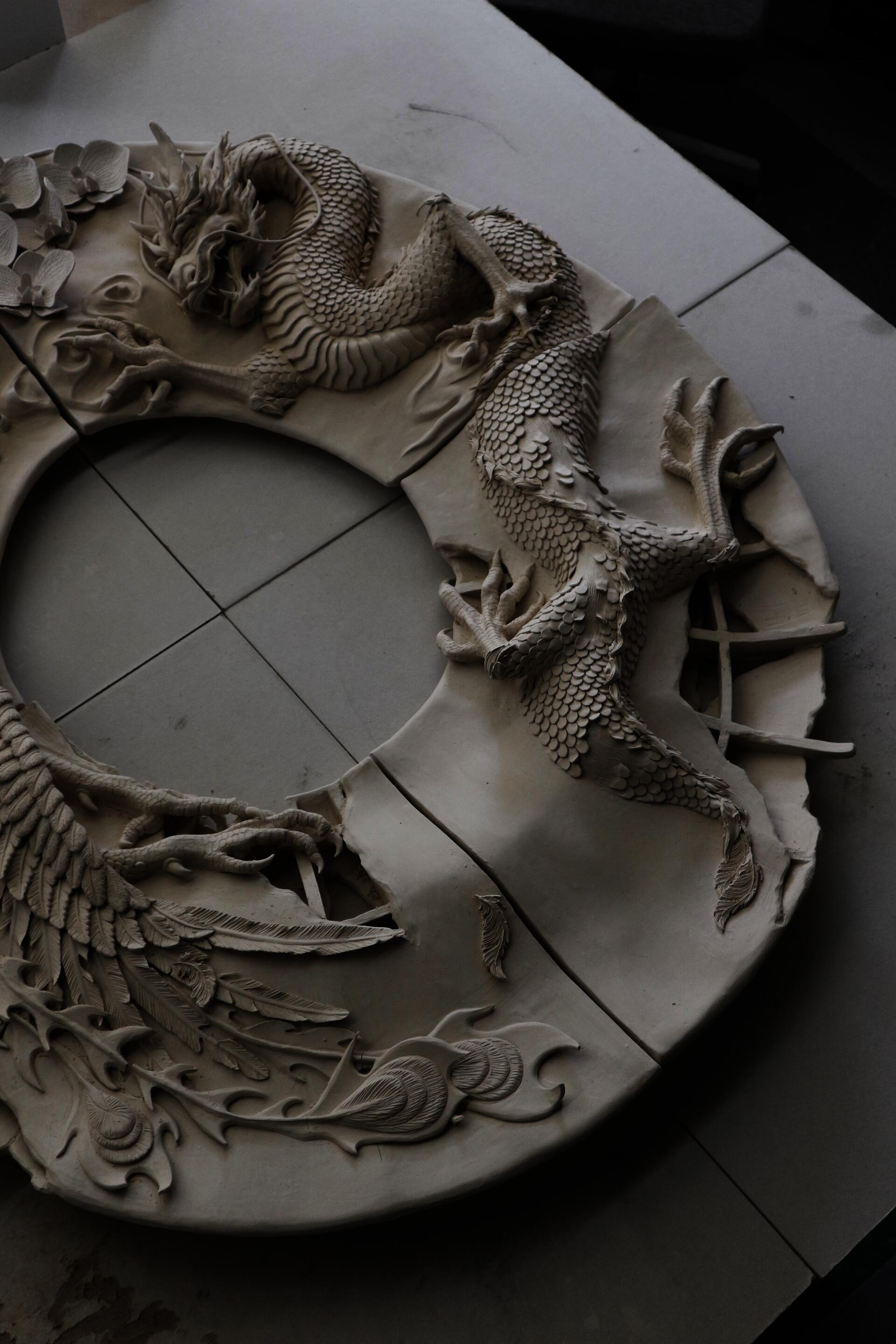 Large ceramic mirror frame with a detailed dragon, phoenix and orchid sculptures on the surface.