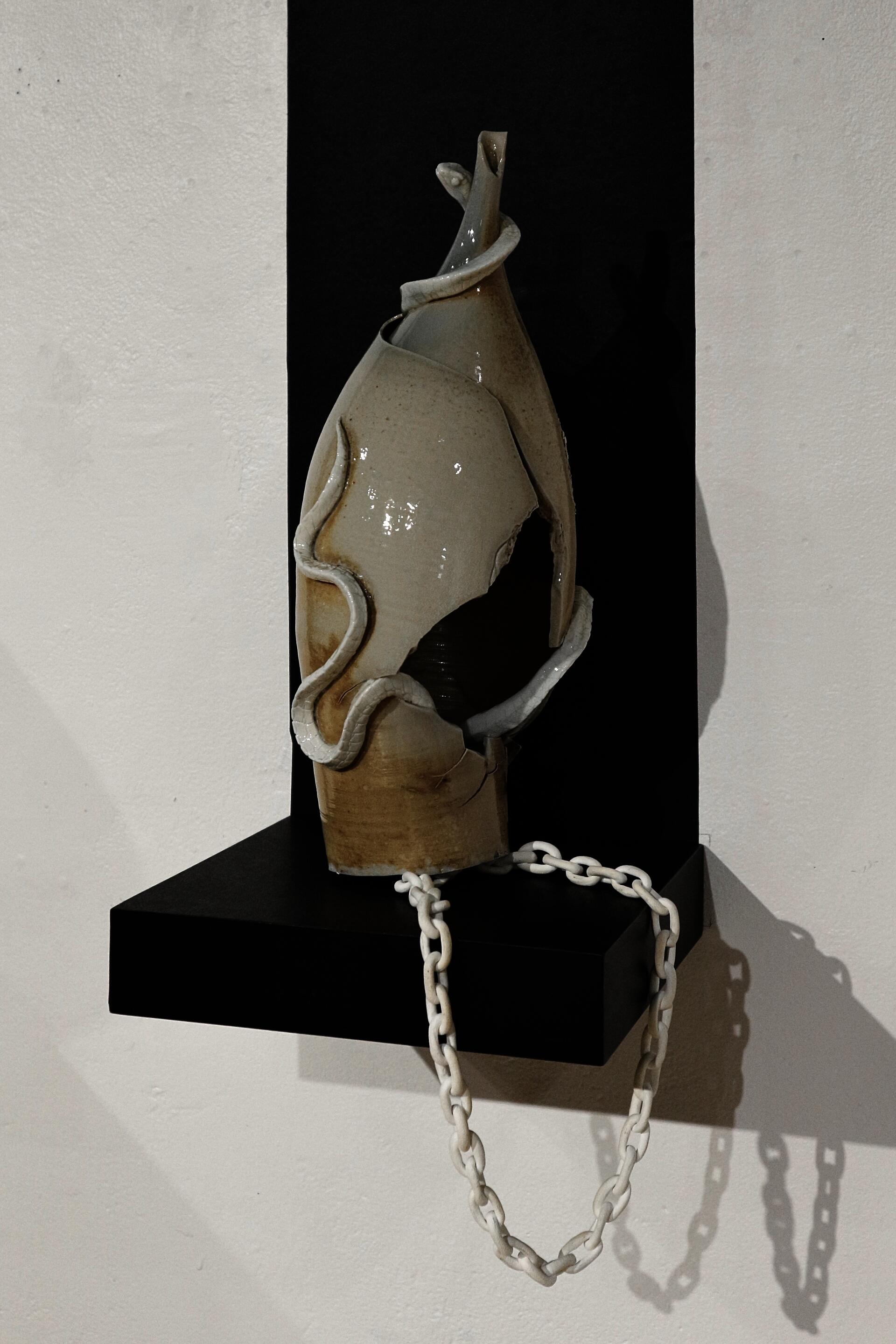 Soda-fired ceramic vessel with hand-sculpted snake around the neck.