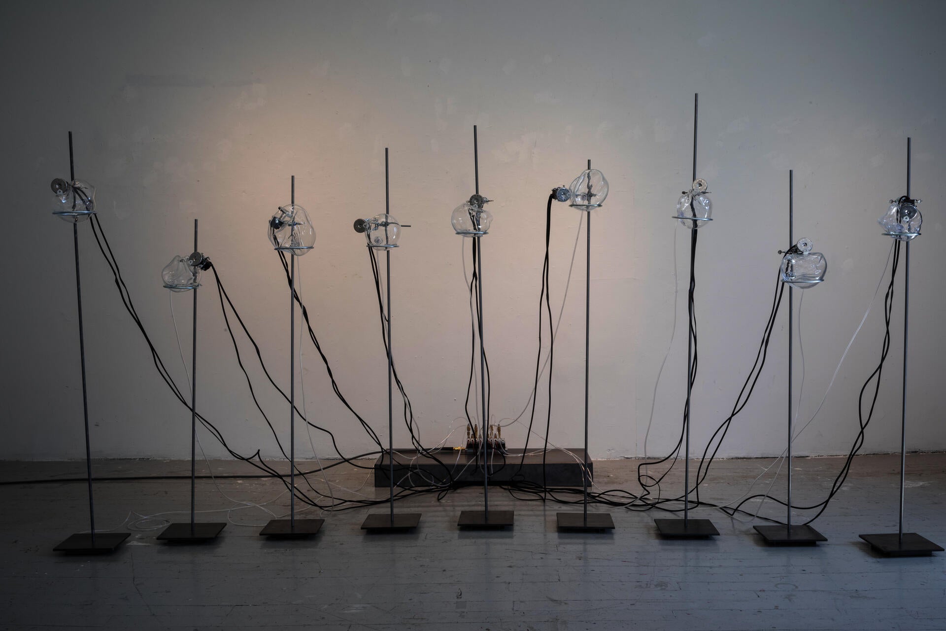 Nine steel stands with glass orbs define a semicircle in the exhibition space with multiple sonic and kinetic elements.