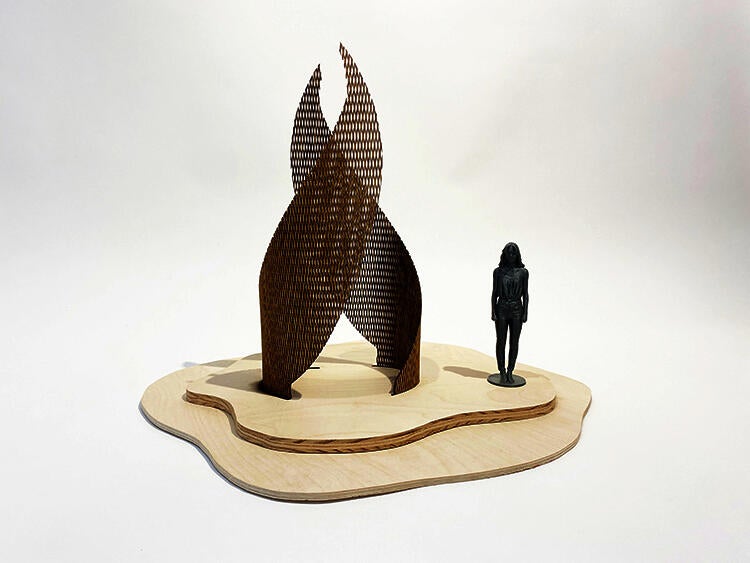 A small wooden prototype with a 3D-printed woman for scale.