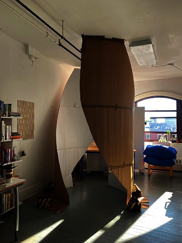 A one to one scale cardboard mock up of a monument in an artist's studio