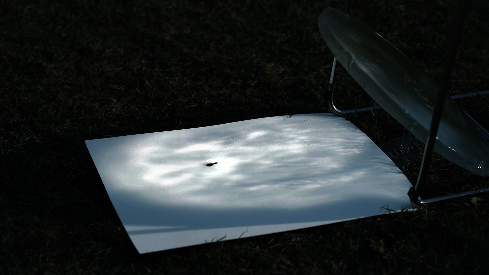 The ice lens burns the paper, the burn mark expanding as the sun moves.