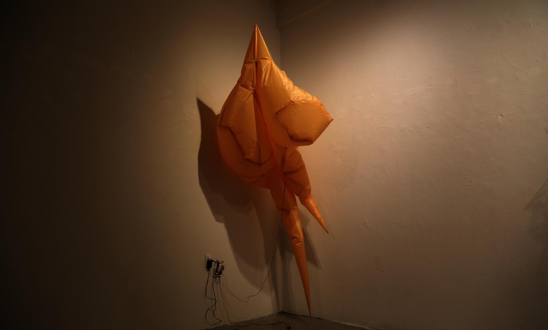 A partially deflated, mirage-like inflatable object made of fabric.