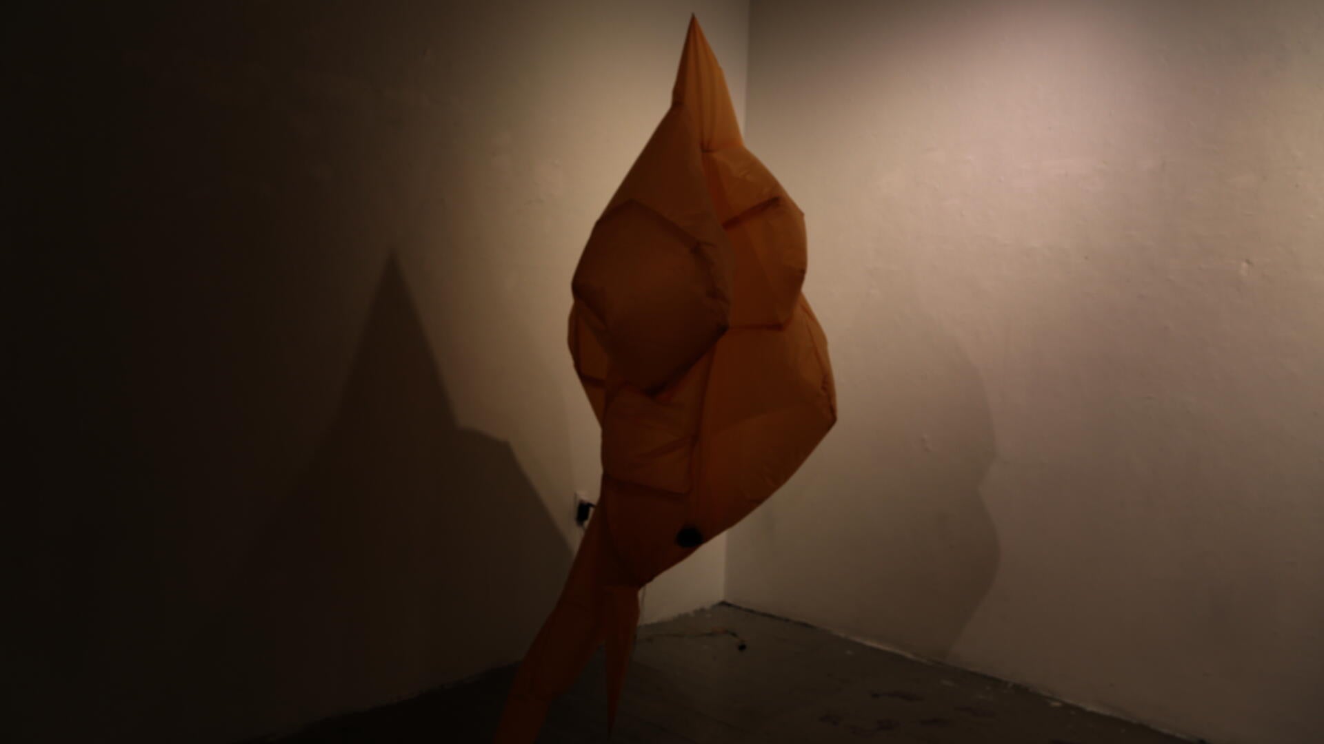 A significantly deflated, mirage-like inflatable object made of fabric.