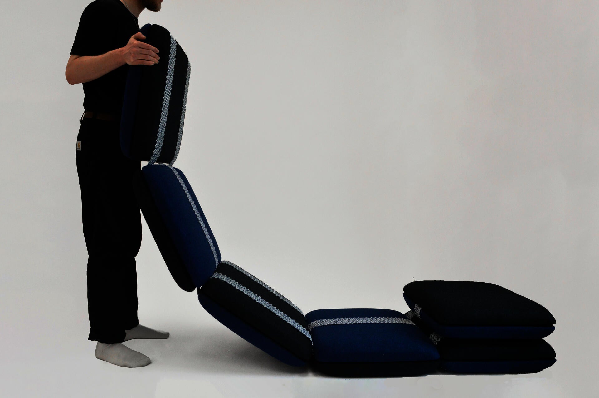 A flexible seating system comprised of tiled upholstered cushions and held together with webbing.