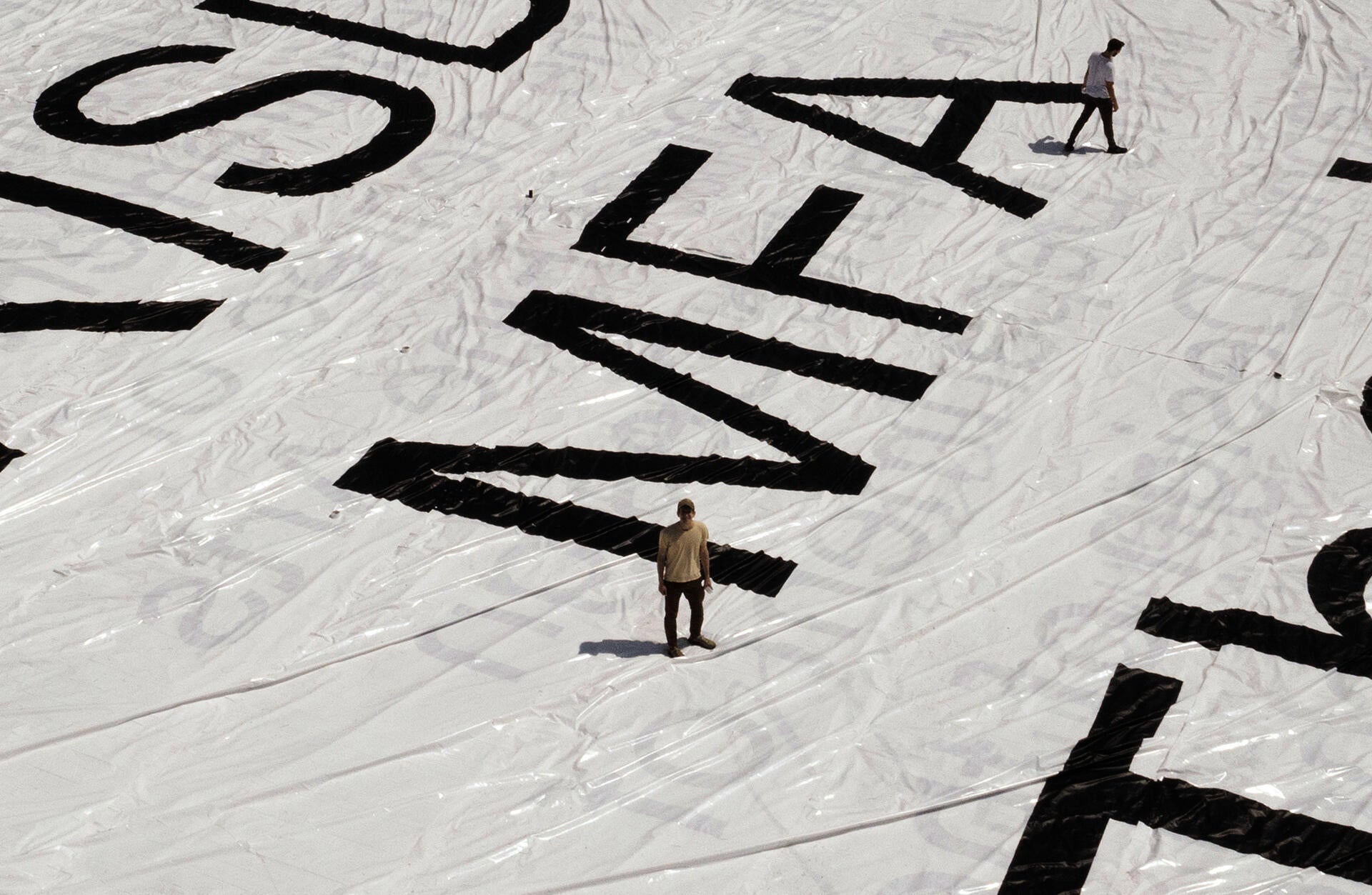 Ben Denzer standing on cover of his 200 x 125 ft RISD MFA Thesis book