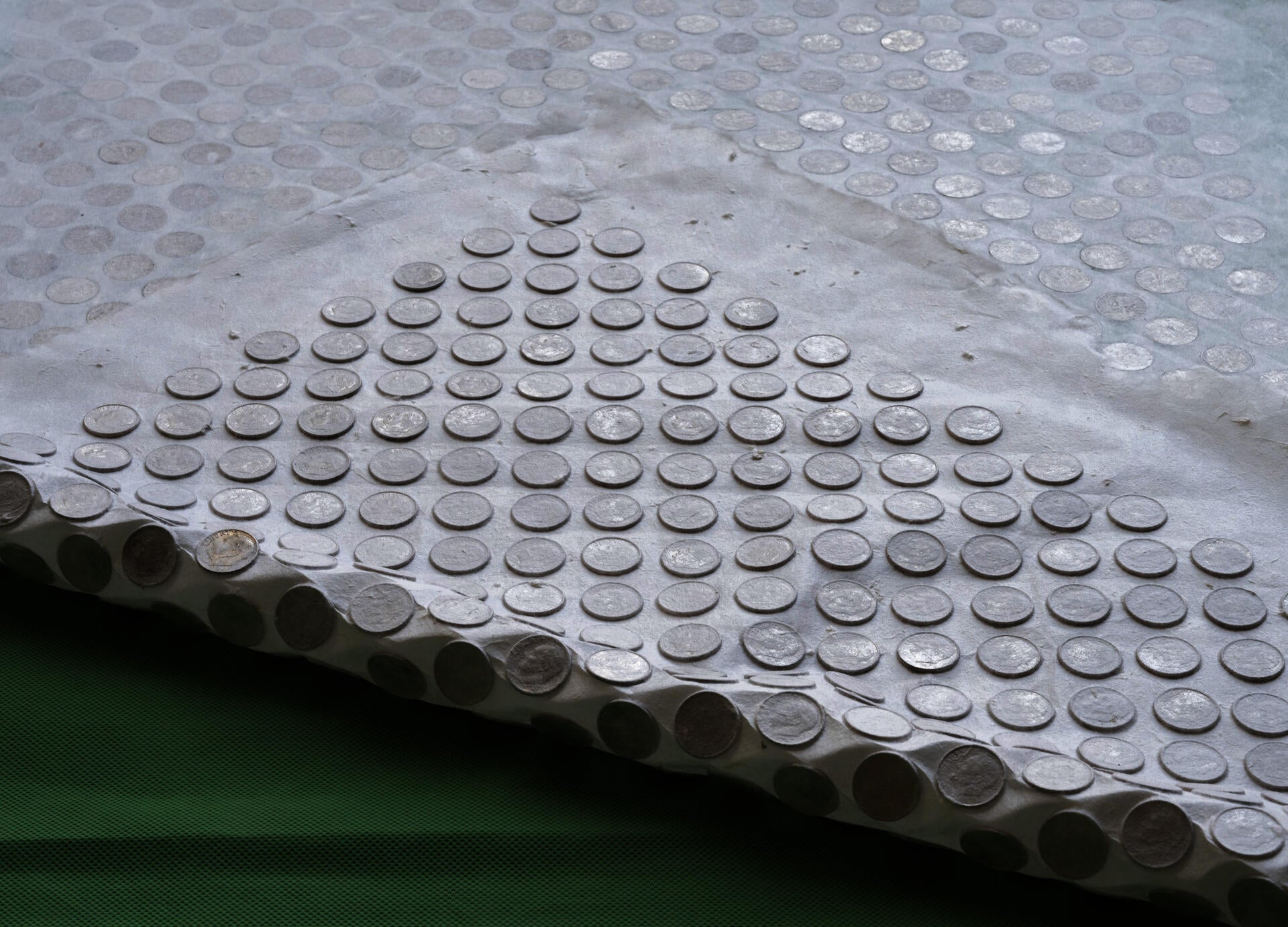 Paper with dimes embedded within it.