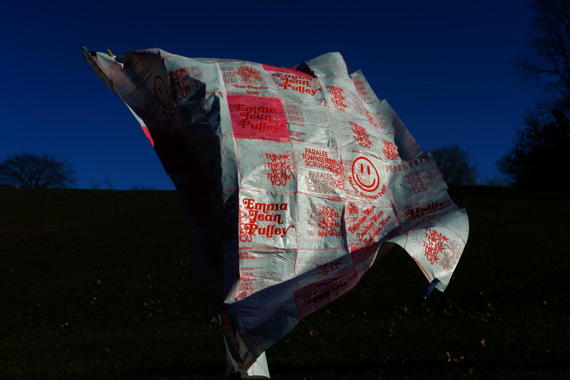 A white textile made of plastic bags with red-colored graphics.