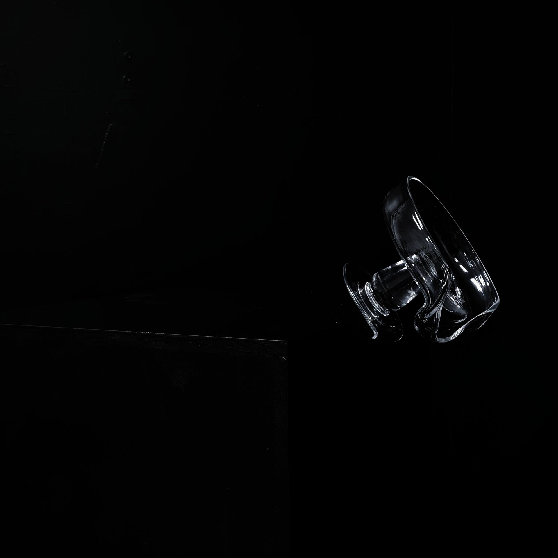 A slumped hand-blown goblet hanging at a pedestal precariously with its puntil mark.