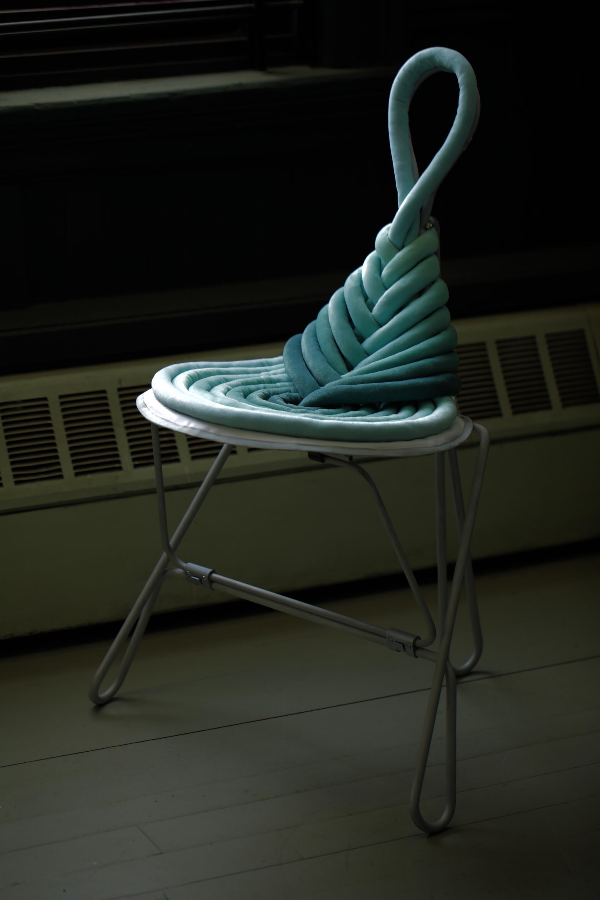 Green knot folding chair beside a window