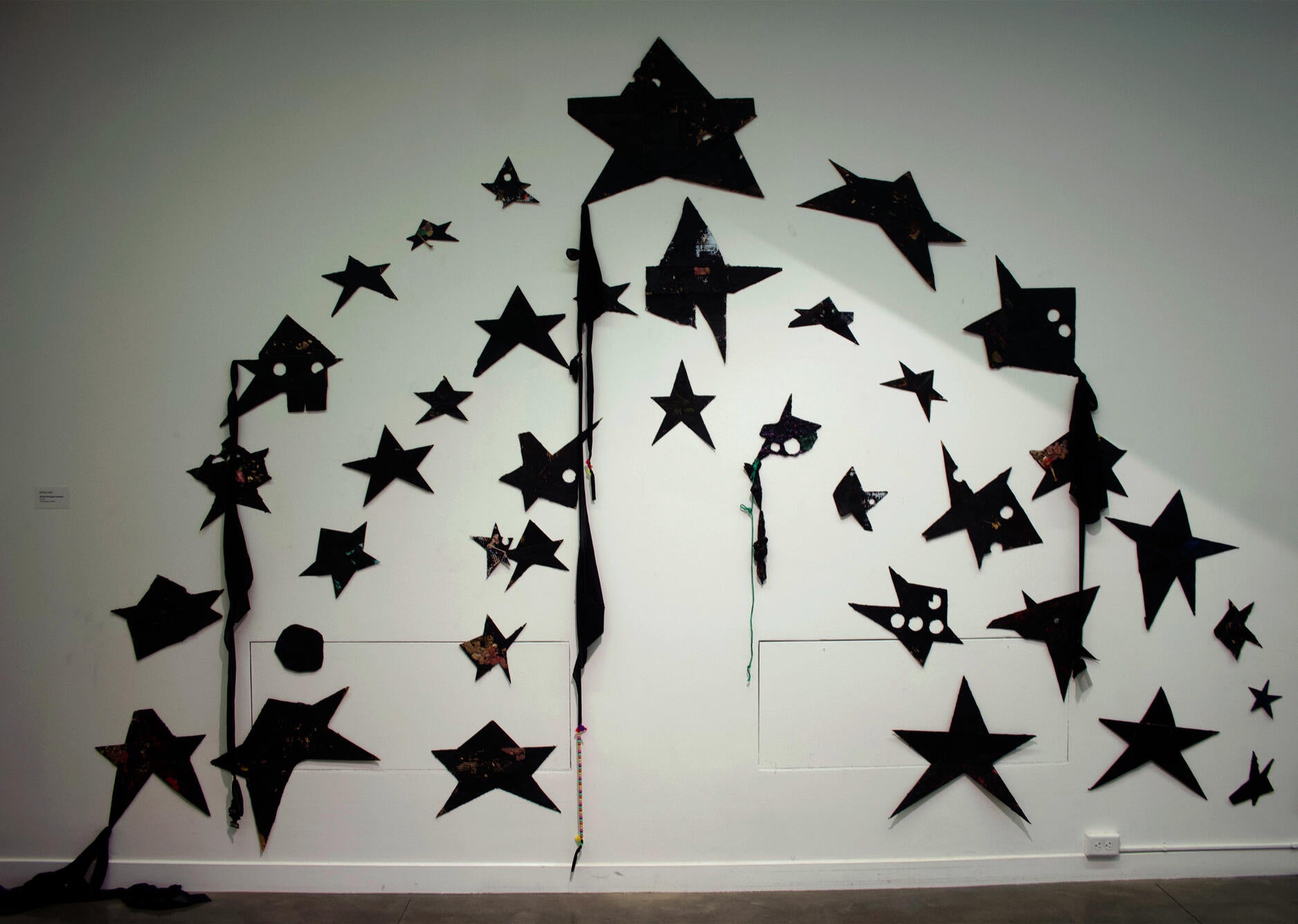 cardboard cutouts with mixed-media mounted in a series of arching manner