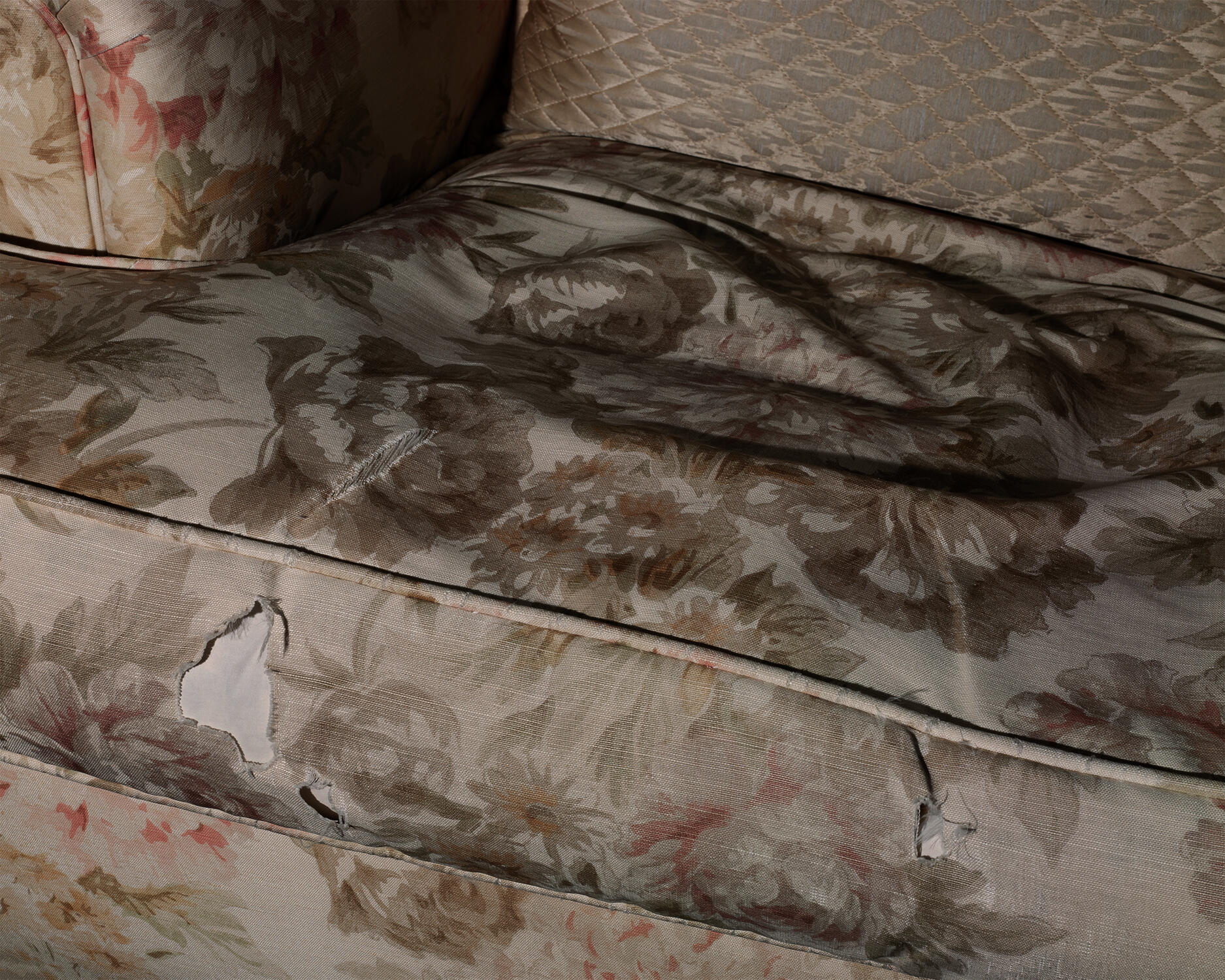 Color pigment print of indent on floral chair cushion from an absent sitter.