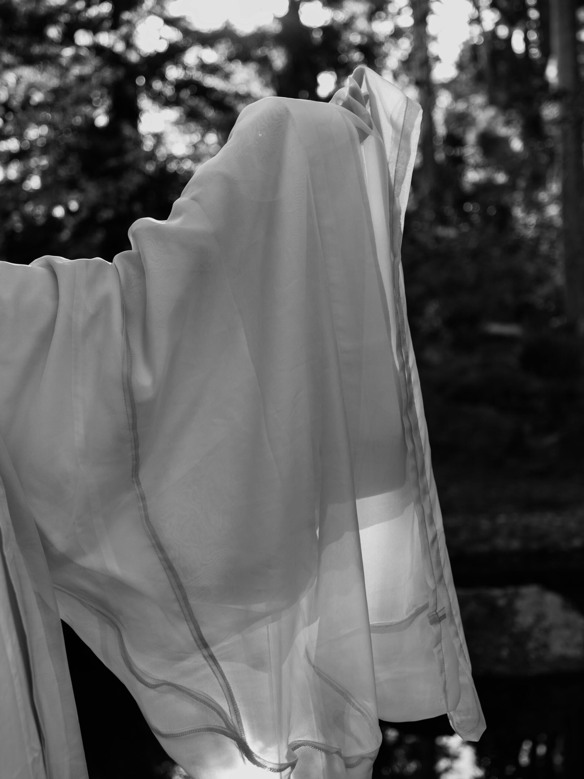 A partial of a figure wearing white silk