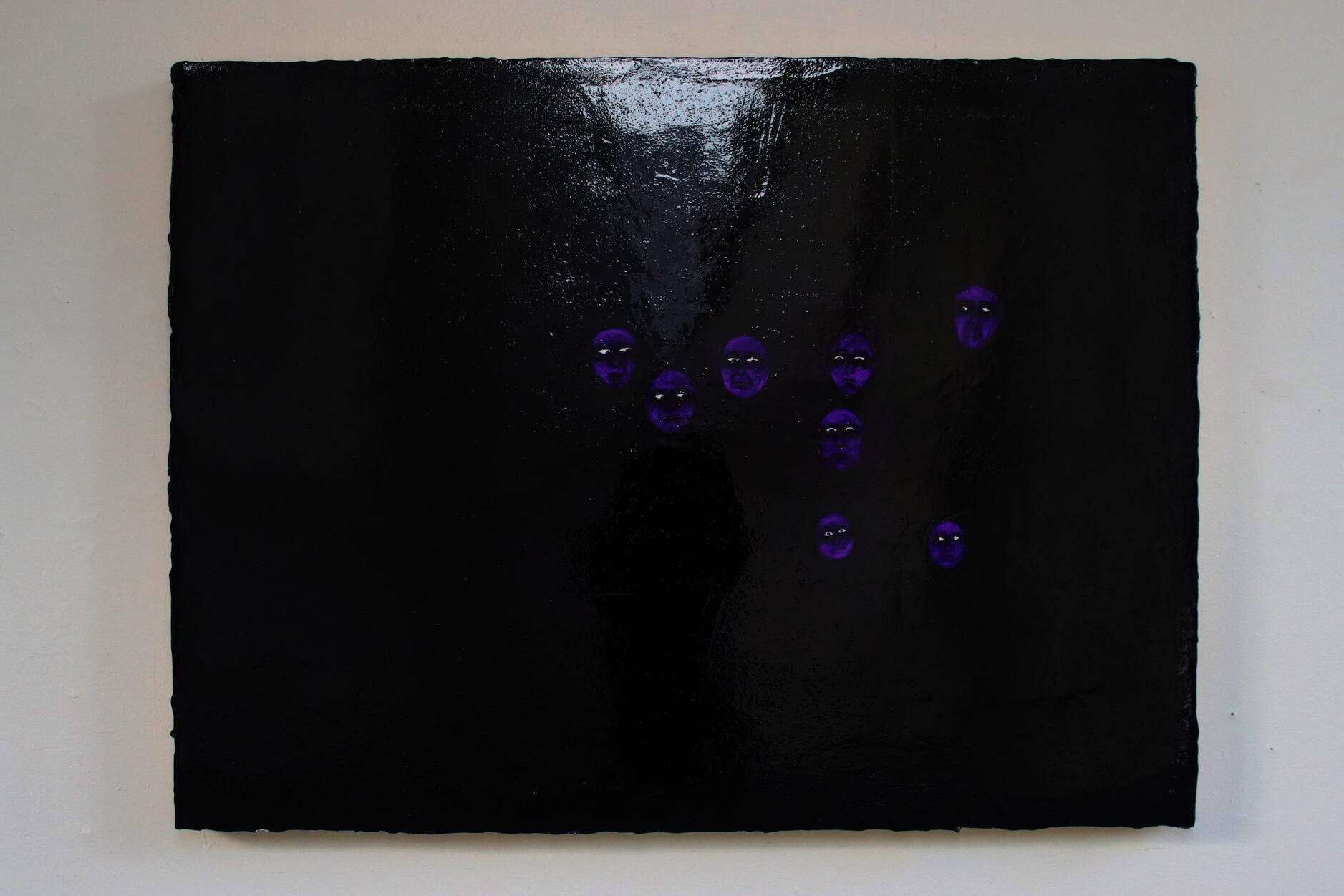 A reflective violet painting with only visible faces 