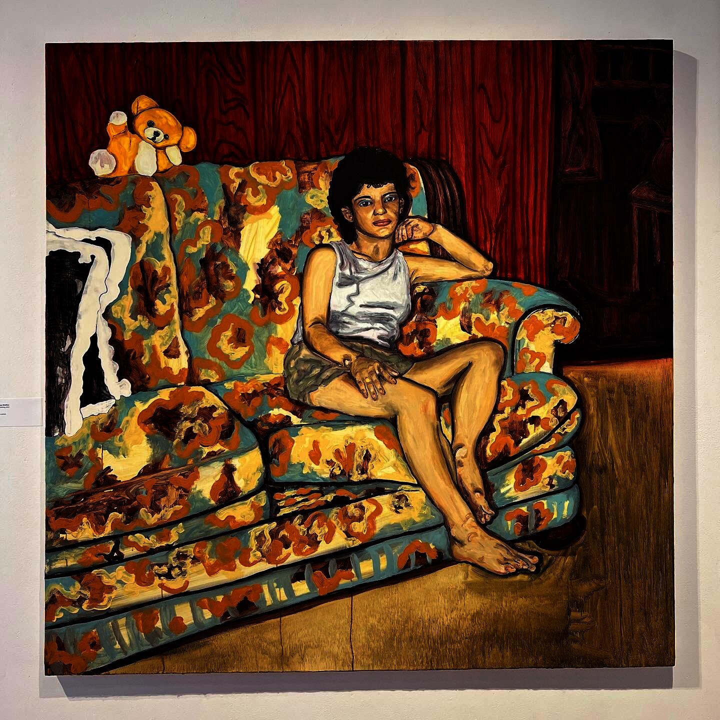 A female figure sitting on a floral couch