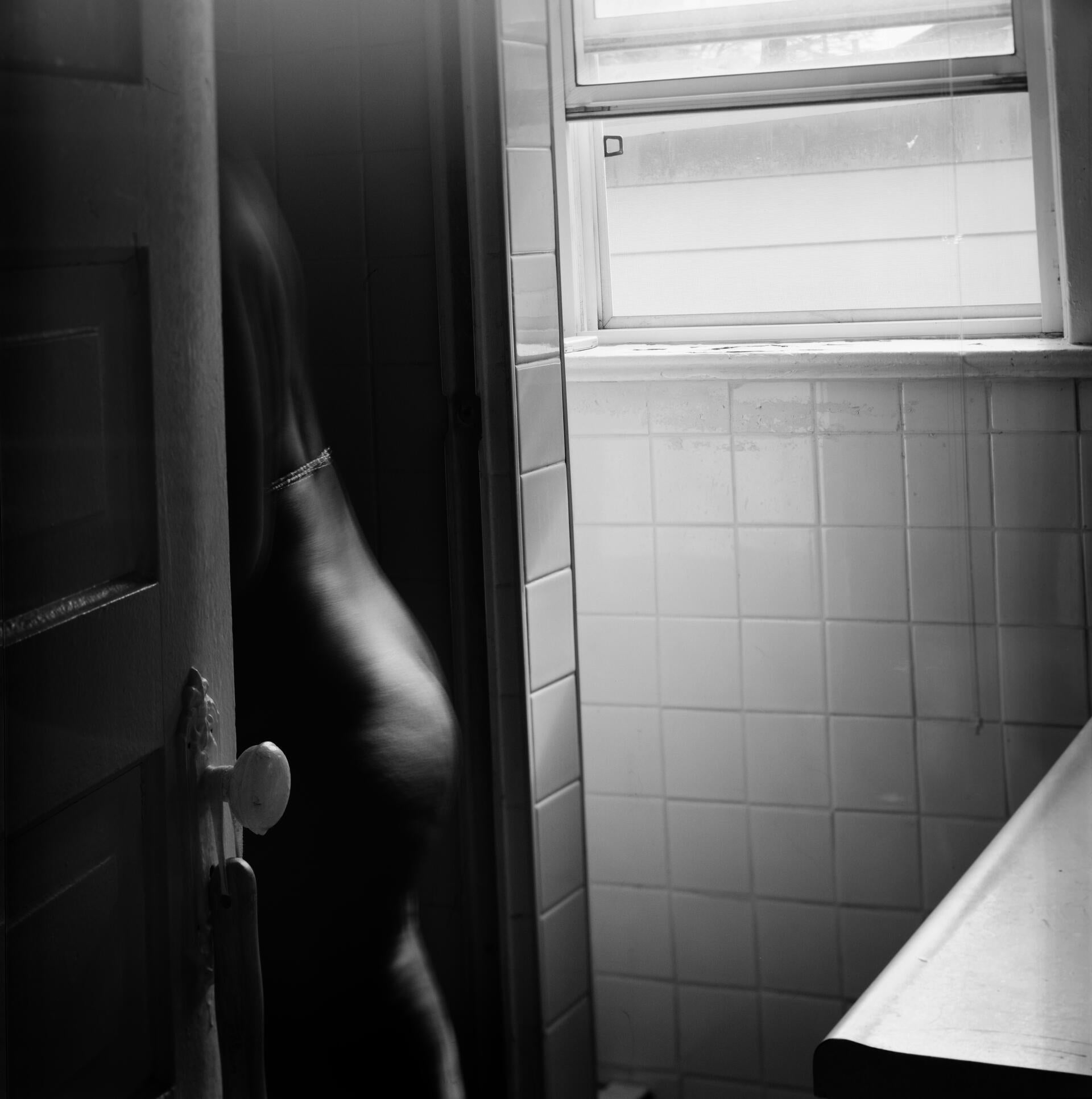 a shadowed figure crosses a threshold