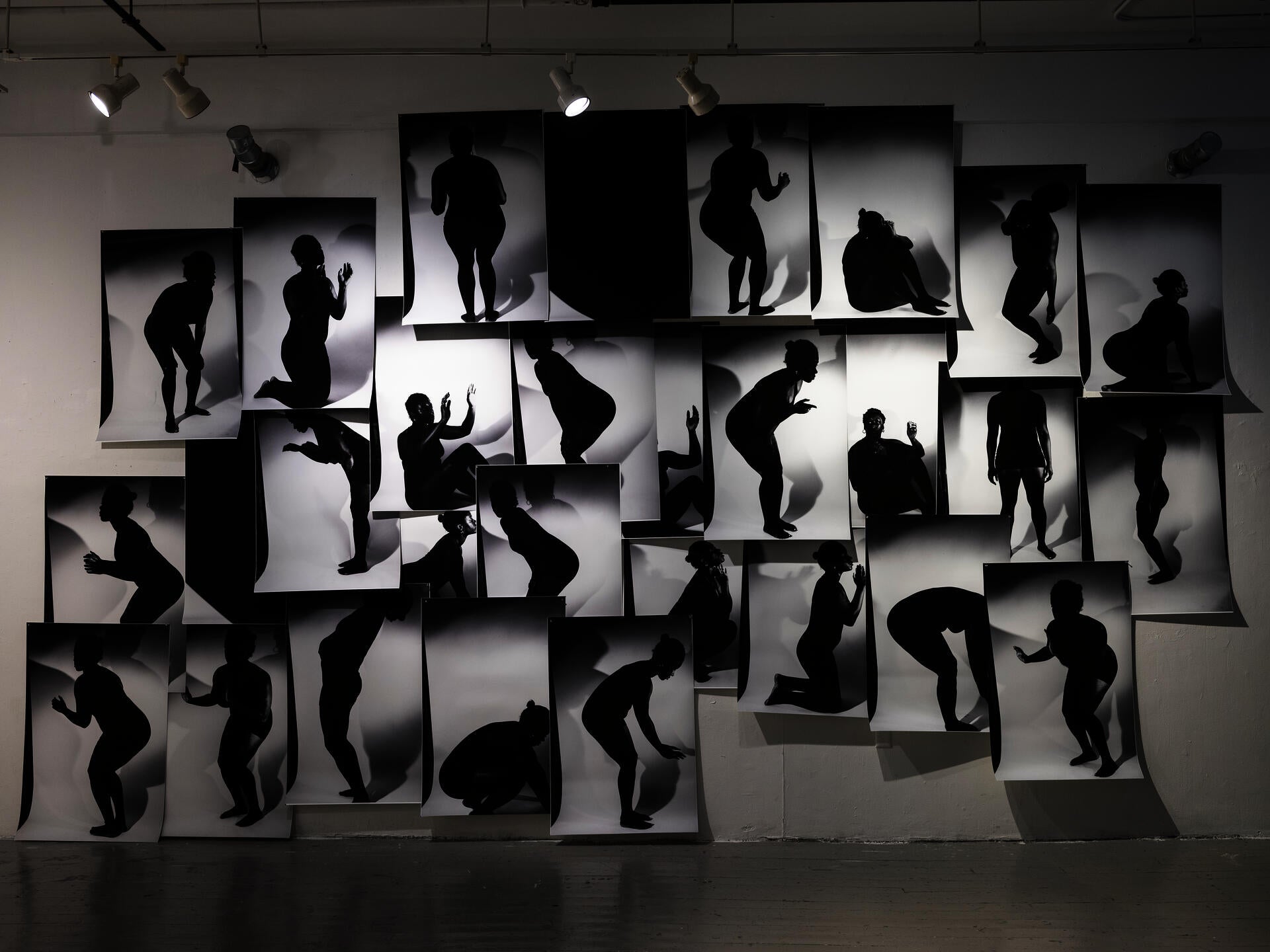 a massive collage on a wall with black and white silhouette images