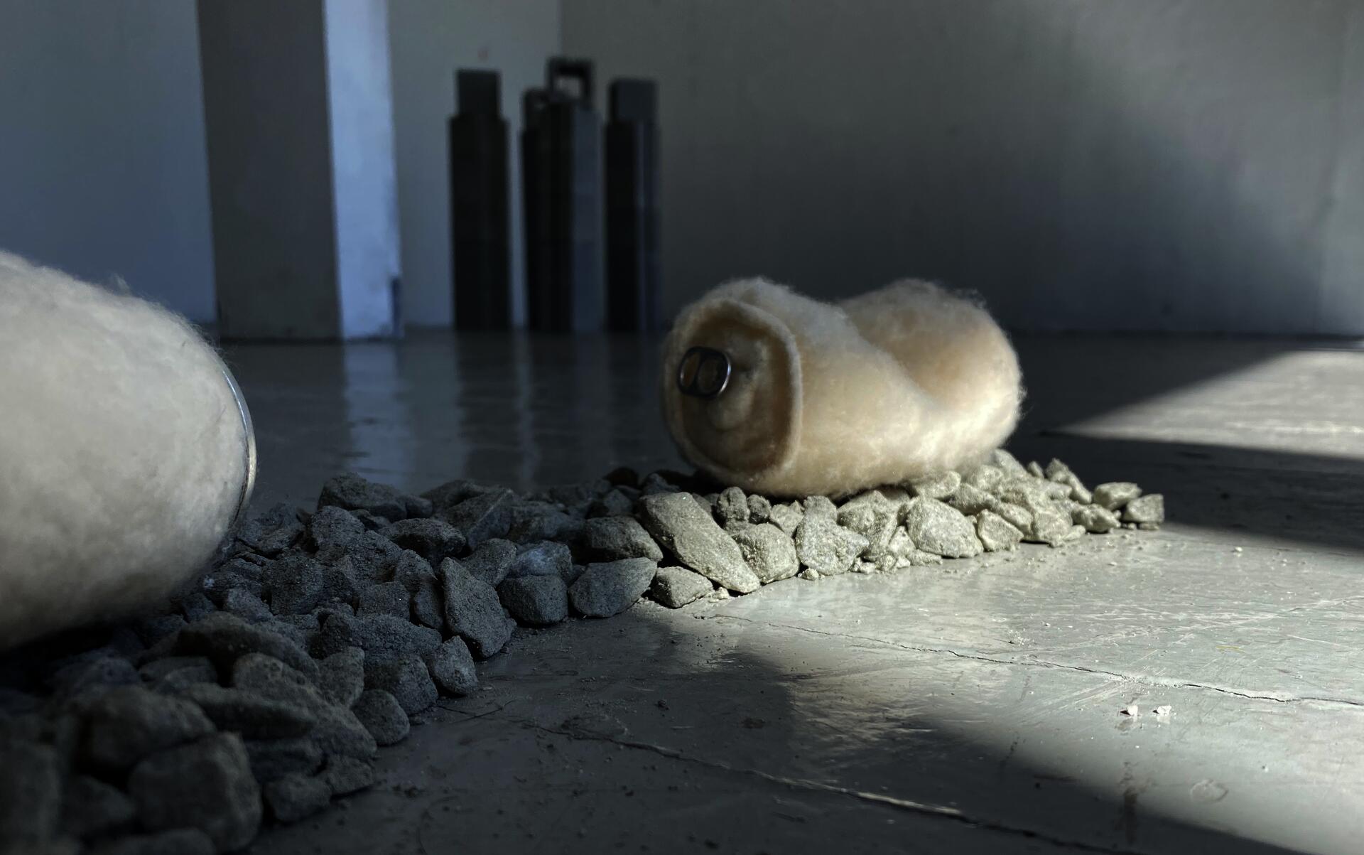 A felted aluminum can sits atop a bed of loose gravel.