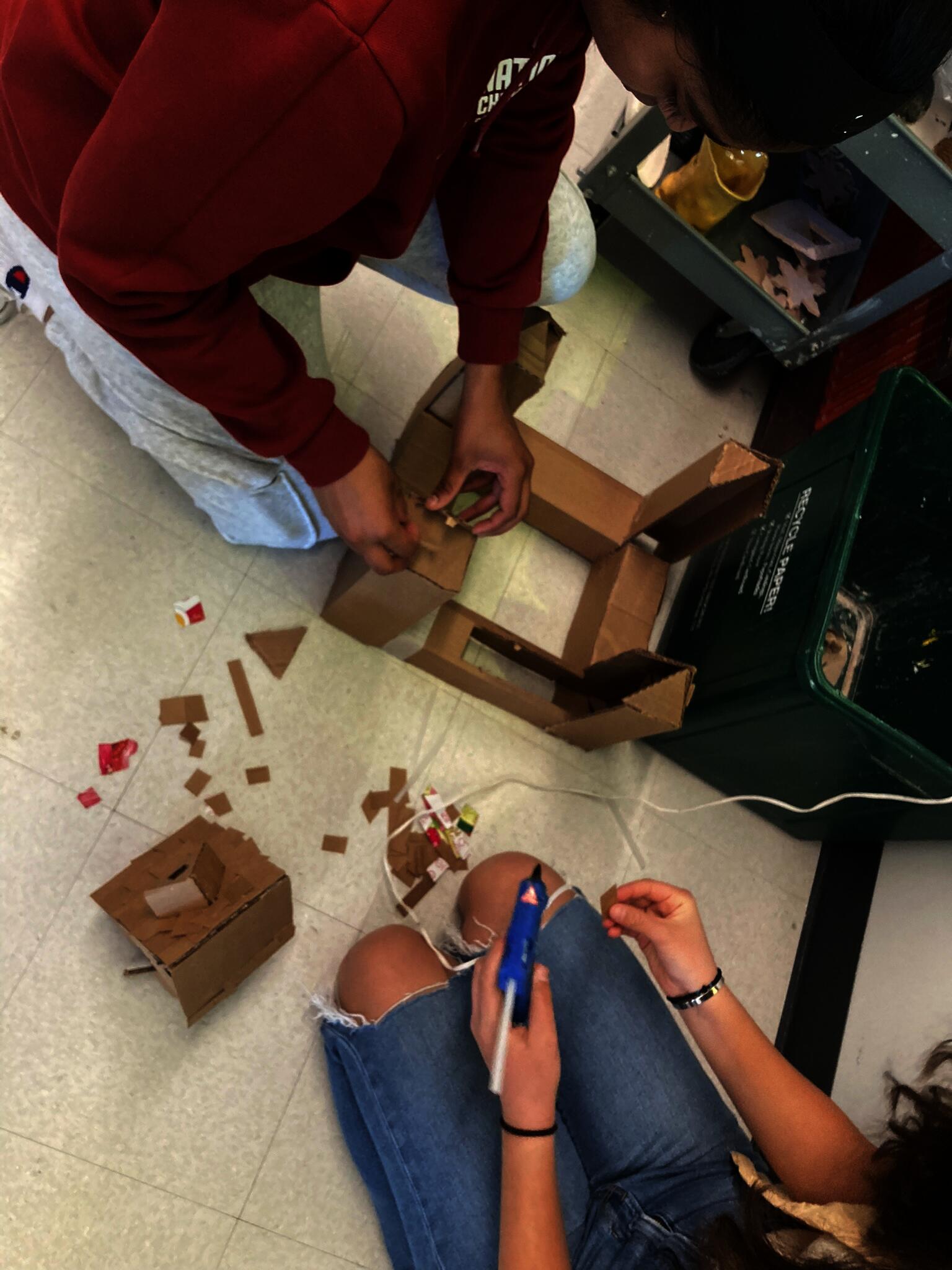 High school students build sculpture with cardboard and hot glue