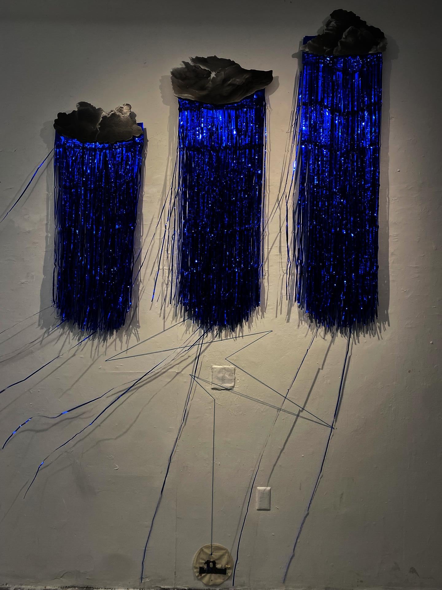 clouds and blue streamers raining over a small image of two figures fighting.