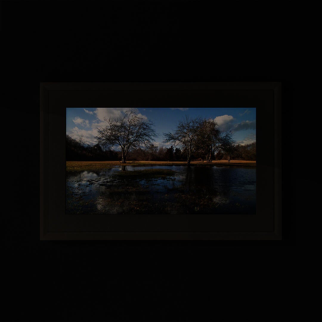 A landscape photograph framed and mounted on the wall.
