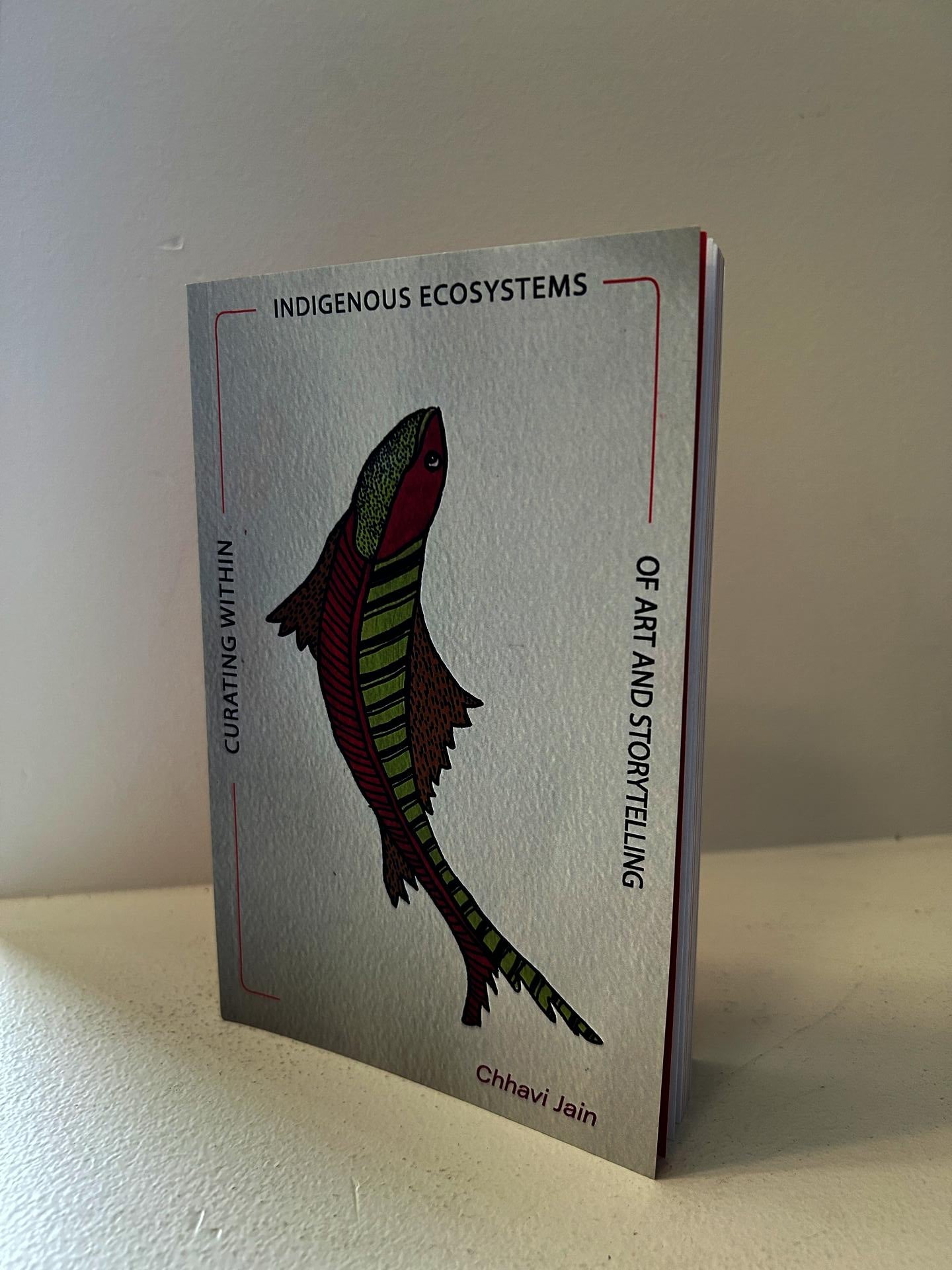 Image of the Book featuring an artwork- pink and green fish looking upwards.