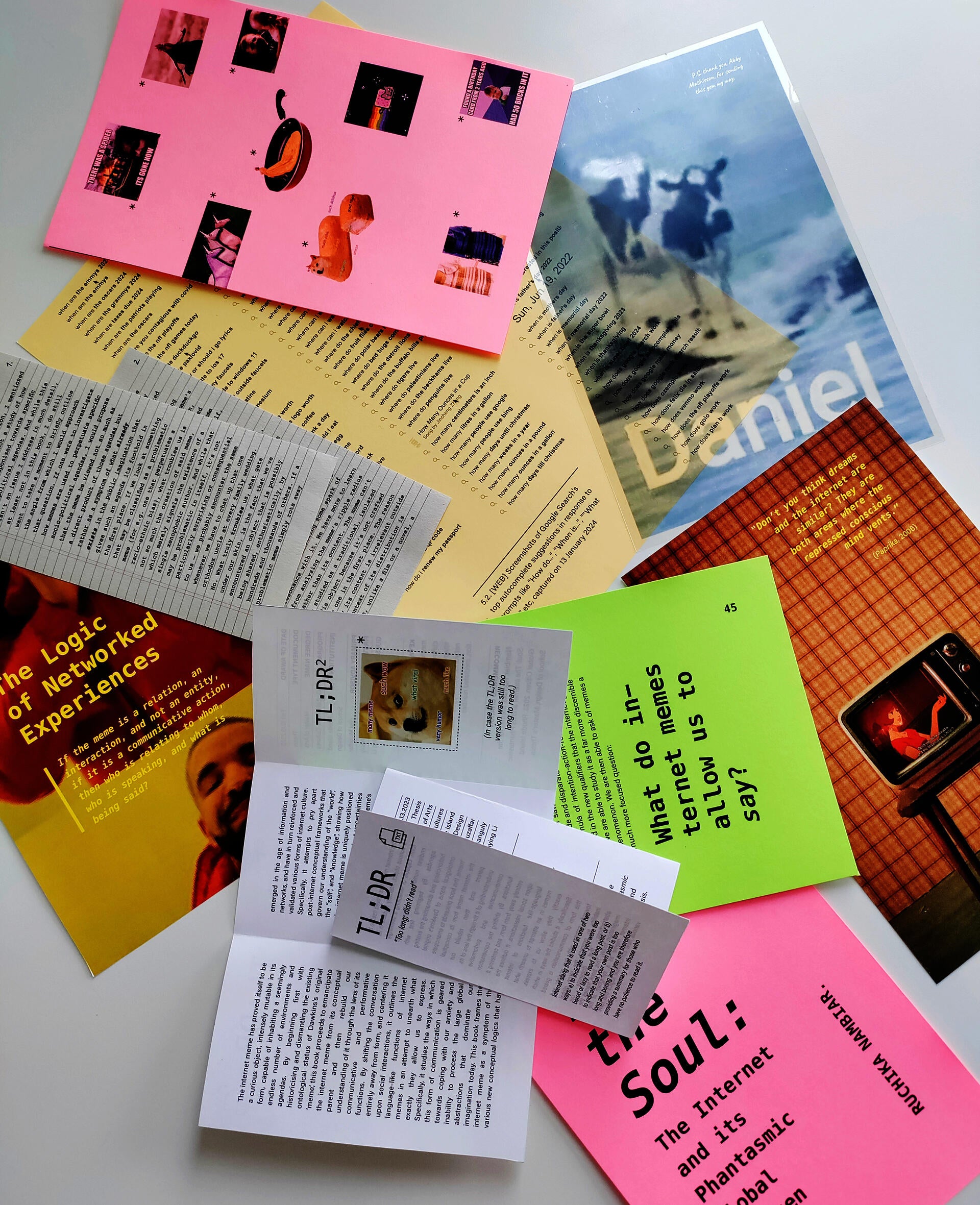 Loose pages strewn over a table, printed on different materials like paper, cardstock, acetate, newsprint.