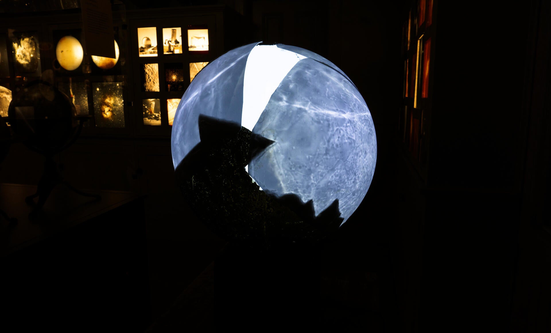 A broken moon model made by the Soviet Union is repaired by projecting from the glass ball inside onto the plastic shell.