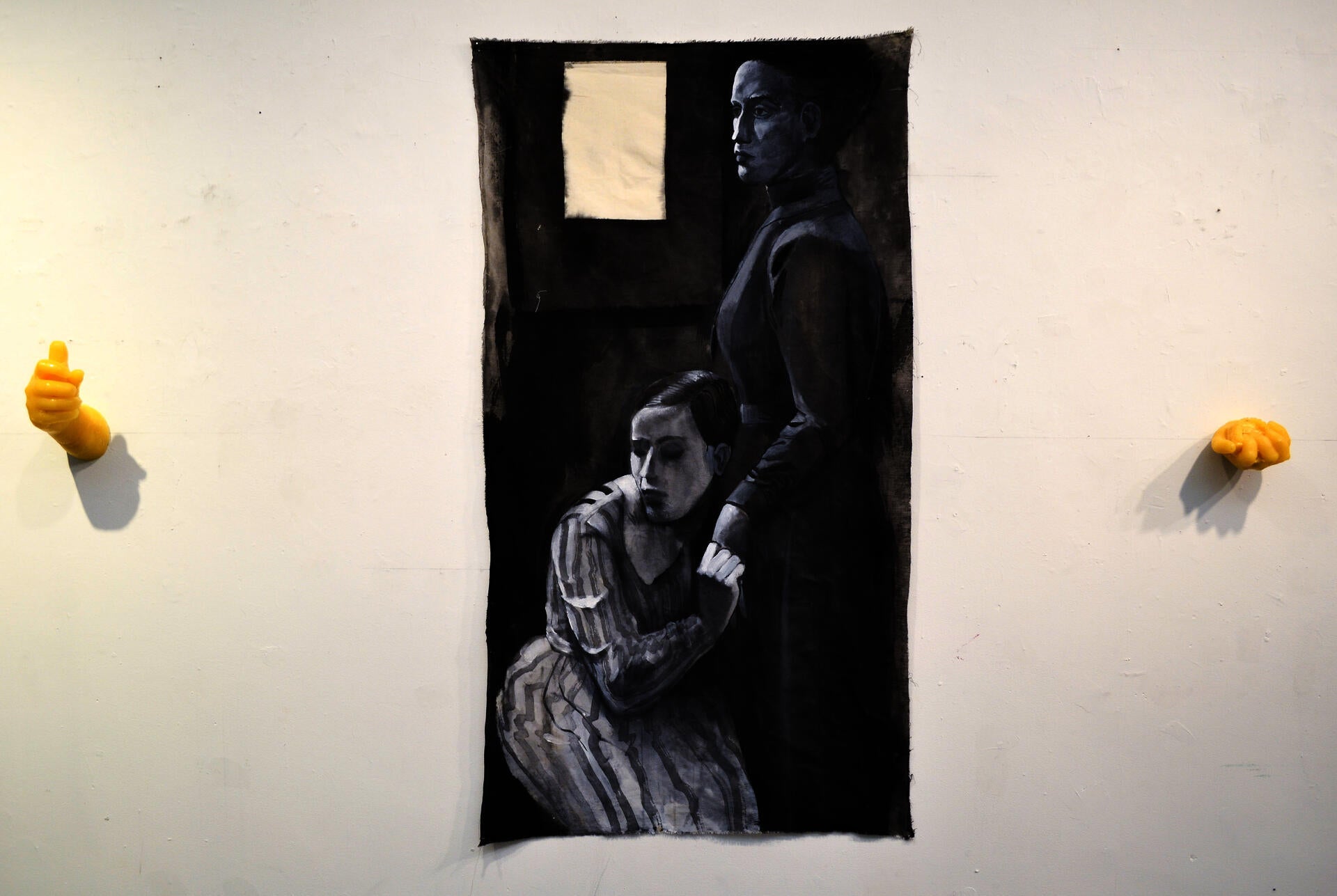 A black and white painting of two women, one is kneeling and holding the other's hand. 