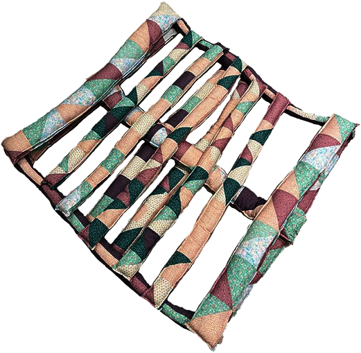 Soft quilted sculpture shaped like a wooden shipping pallet, made from pastel patterned fabric. 