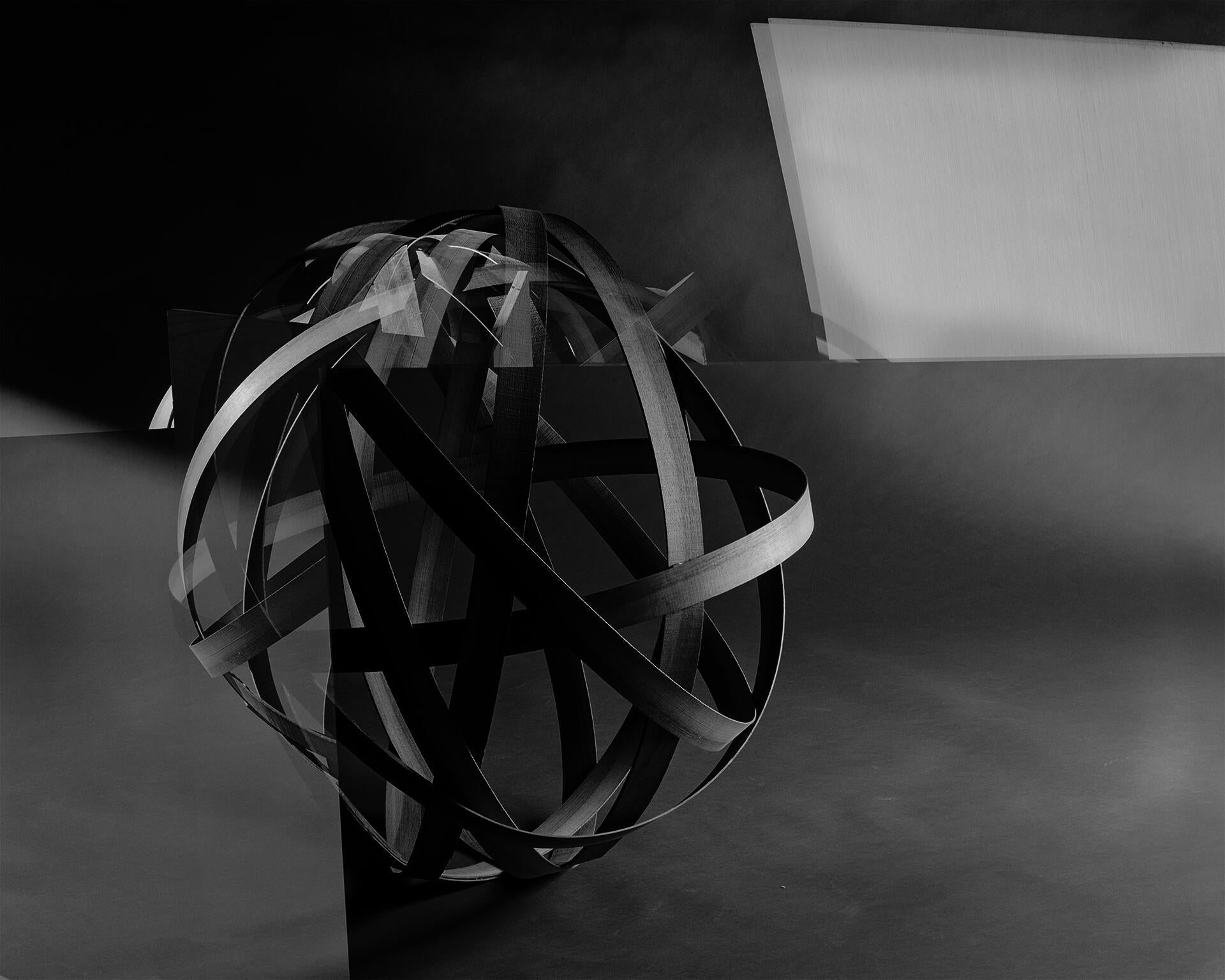 A photograph of bent wood made to look like a globe. 