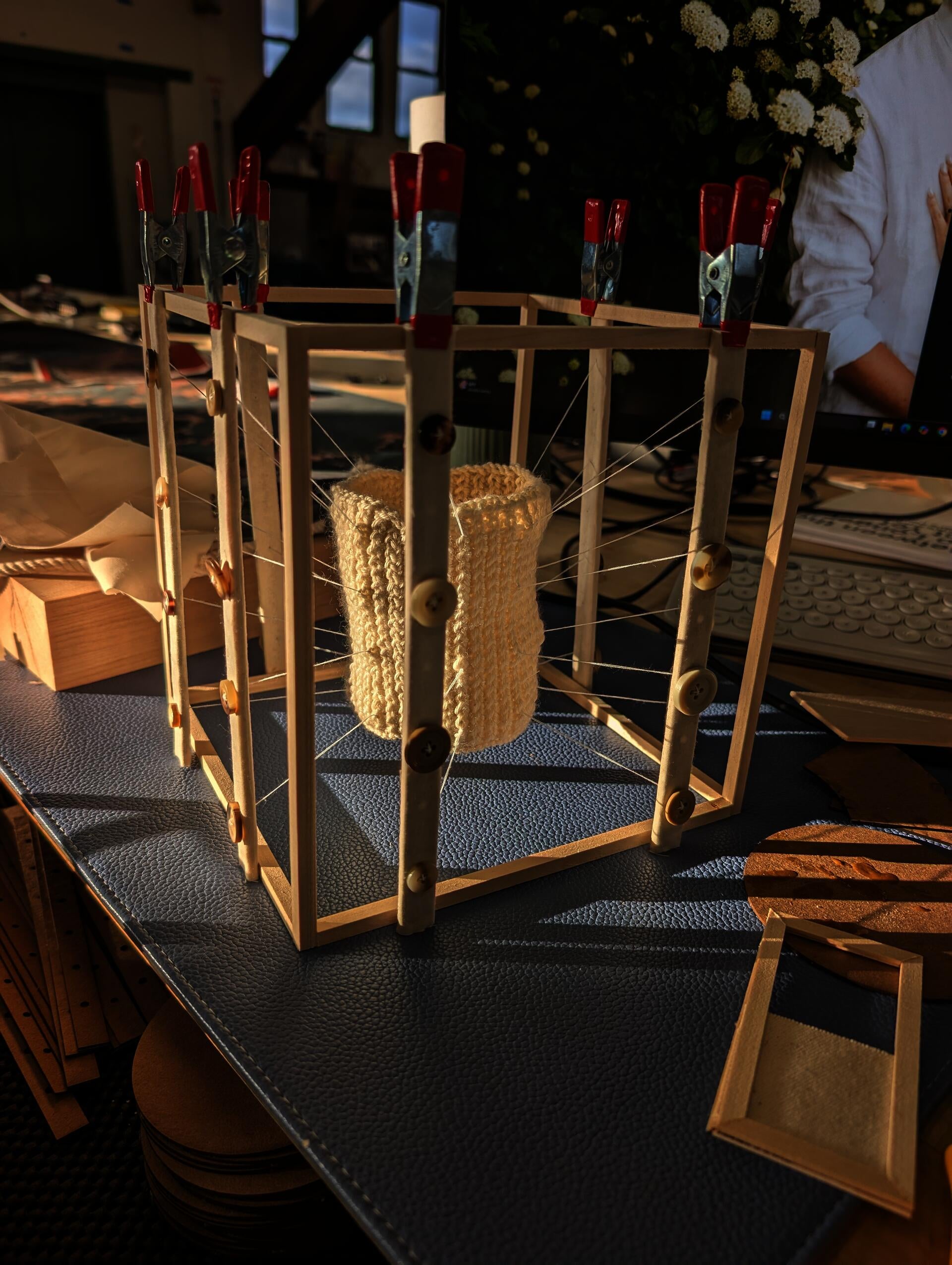 A model with a wooden frame in that supports a pulley system attached to a knitted tube. The tube is kept in tension by the frame and pulley system. 