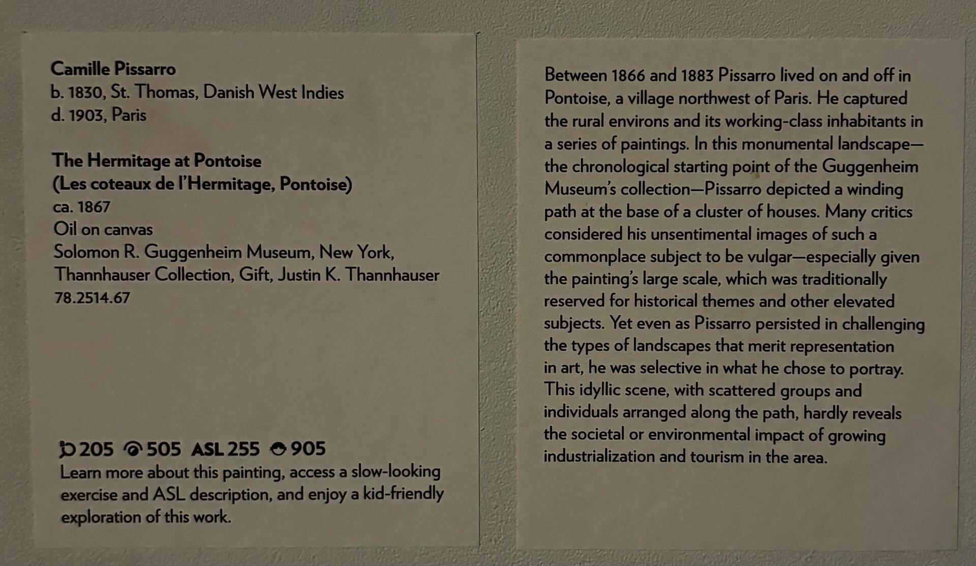 Two rectangular labels affixed to a white wall. The left label lists the artist's name, biographical information, collection details about the painting, and technology tags. The right label shares a brief interpretive description of Pissarro's art practice and approach to landscape painting. 
