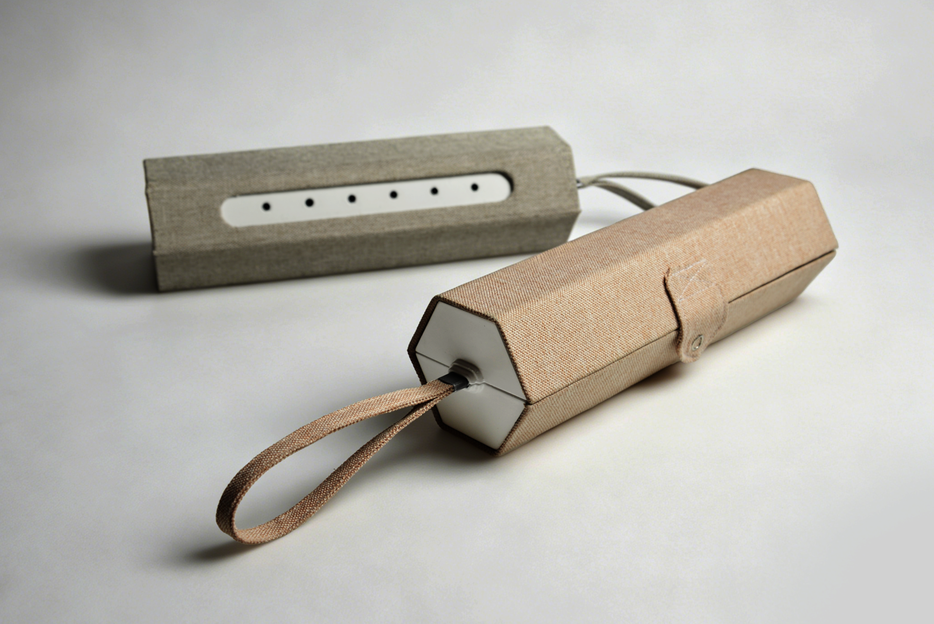 Soft, fabric-covered steam device cases in beige and gray, each with a strap, button closure, and ventilation holes. 