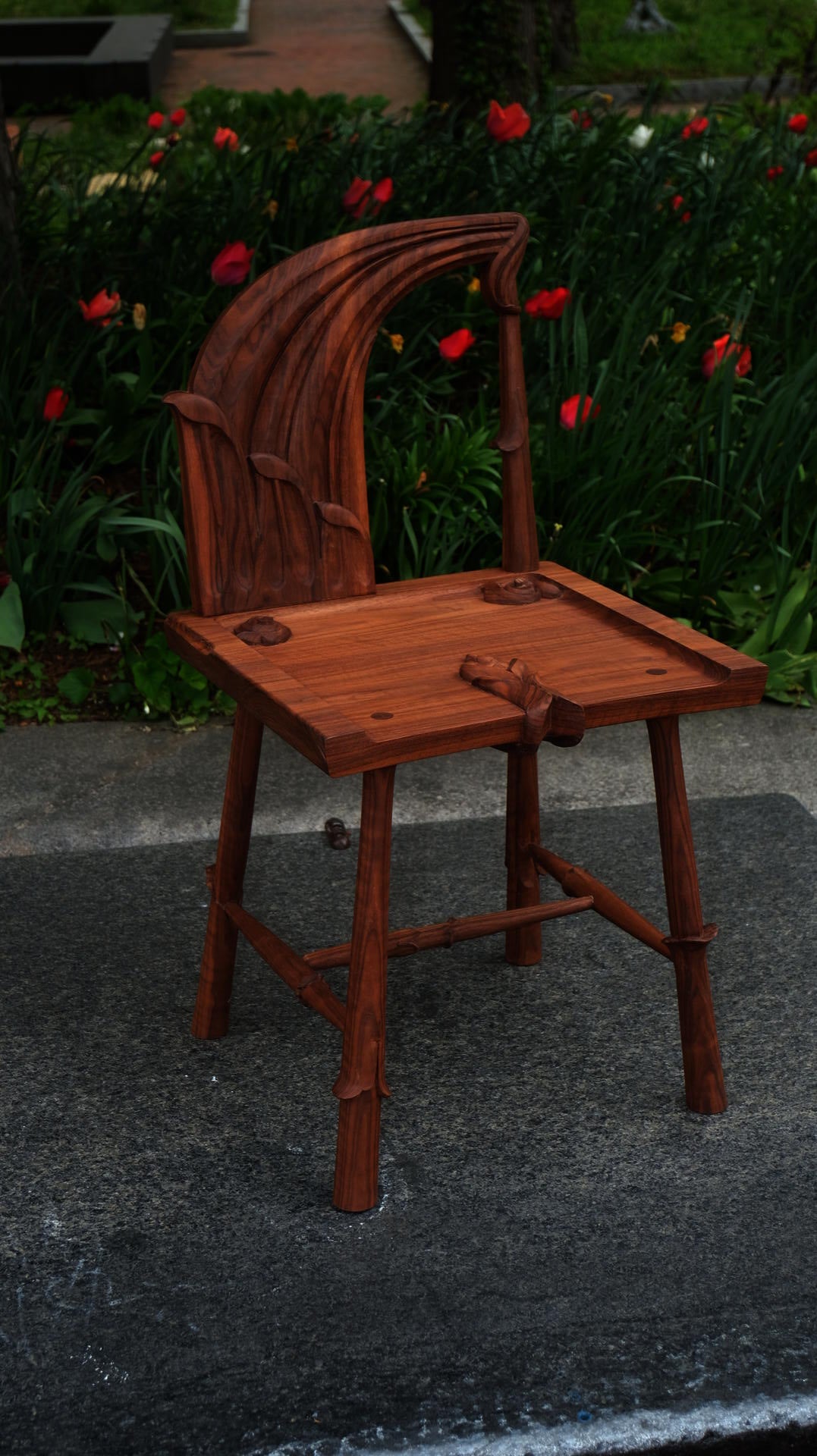 Wooden spindle back chair with curved seat and vertical spindles, 28 inches tall, merging traditional joinery with contemporary organic form.