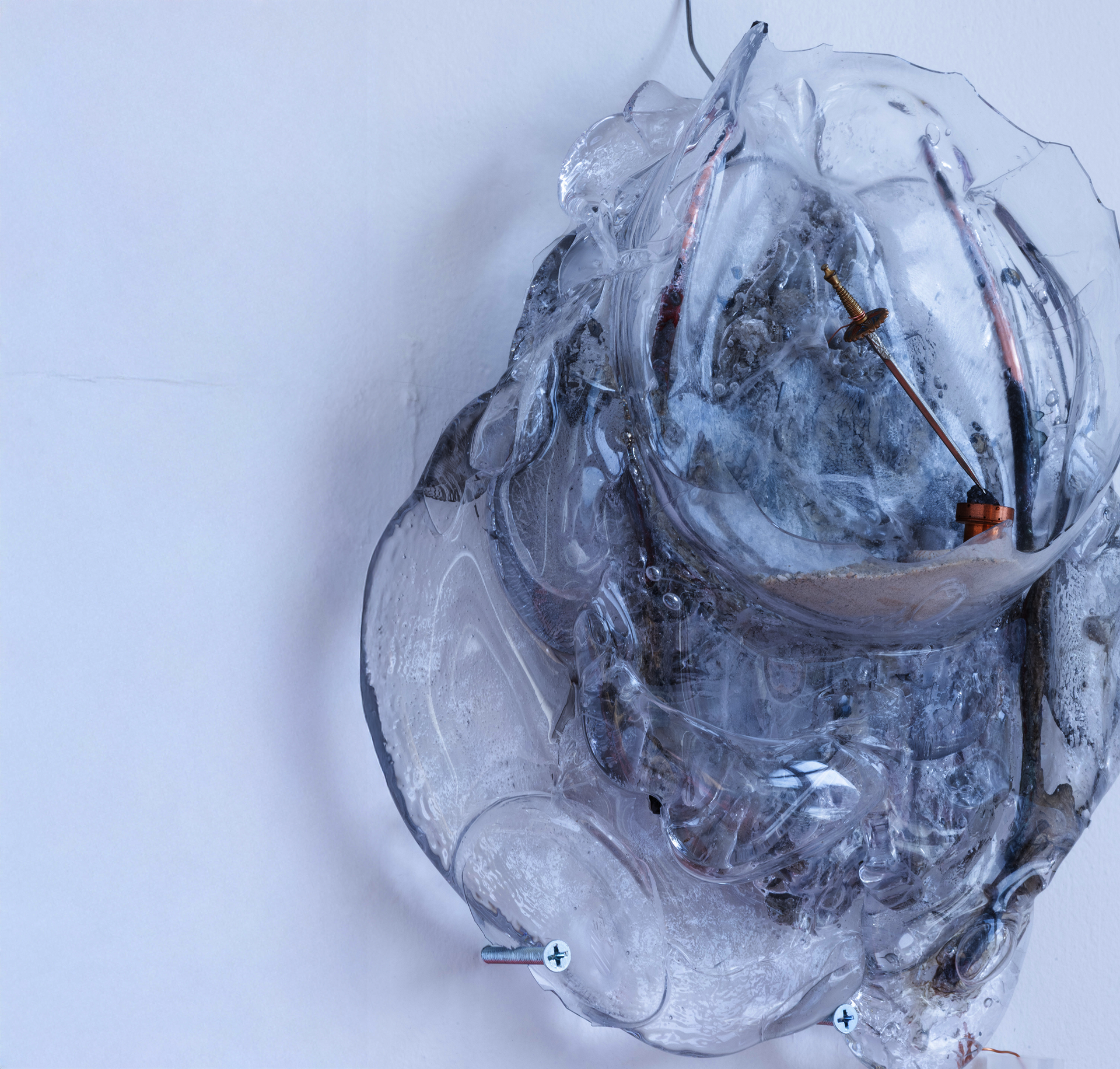 Formless glass lump with wires, and a pocket with sand and a tiny sword