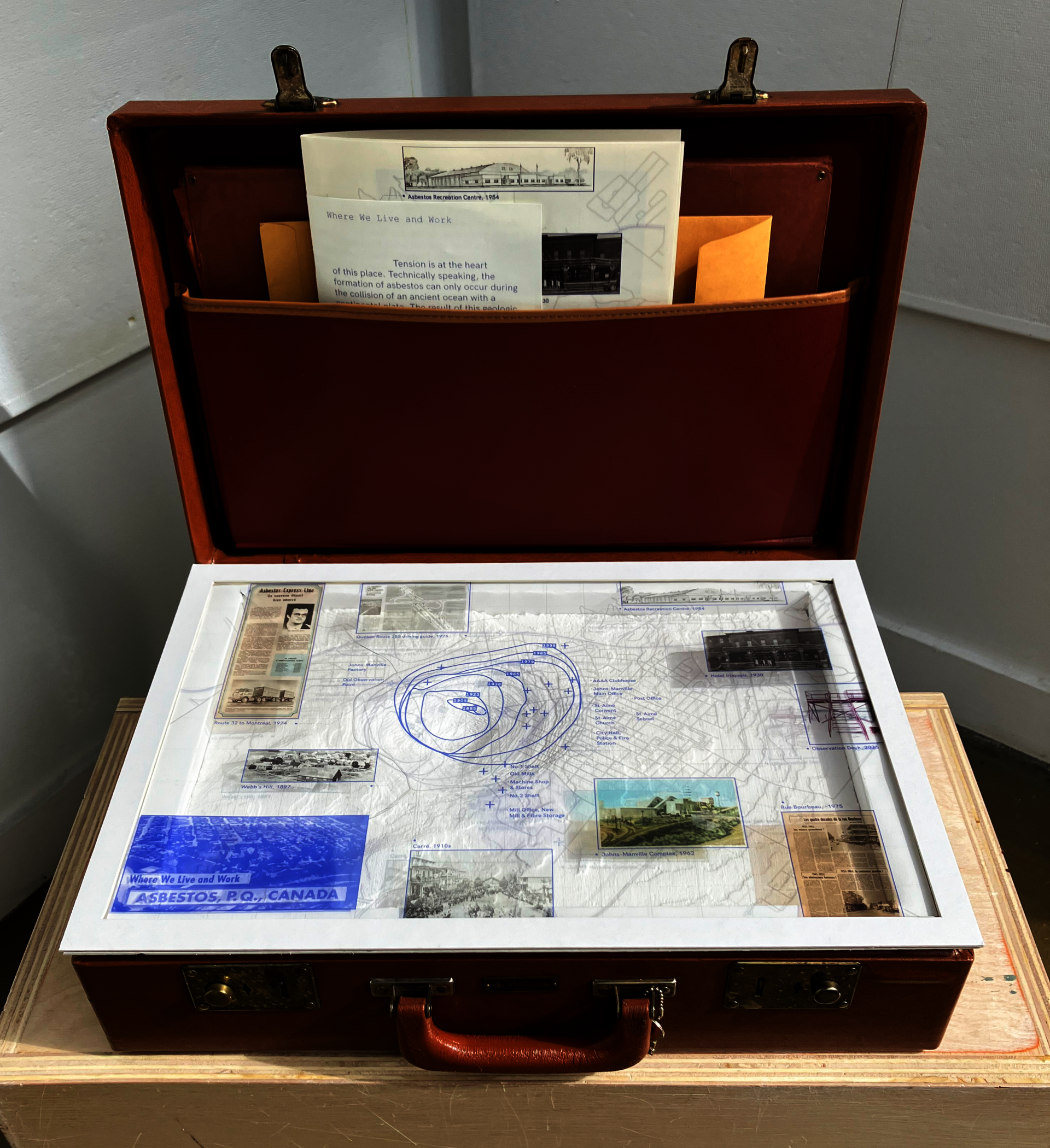 A photograph of the landscape repository which is a briefcase with a CNC model of Val-des-Sources inside, mapping plates that can be placed on top of the model, and narrative atlas booklets.
