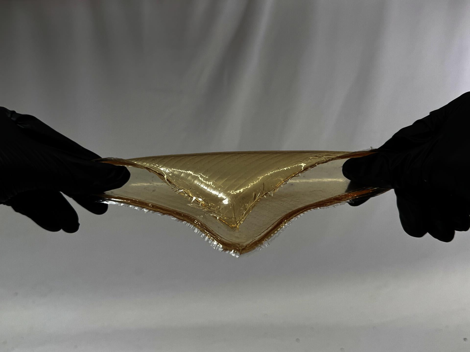 A simple tensile test on a bioplastic made primarily from gelatin. 6 inches by 6 inches. The addition of glycerin provides it with strong tensile properties. The material yellowed noticeably due to oxidation caused by excessive heating.