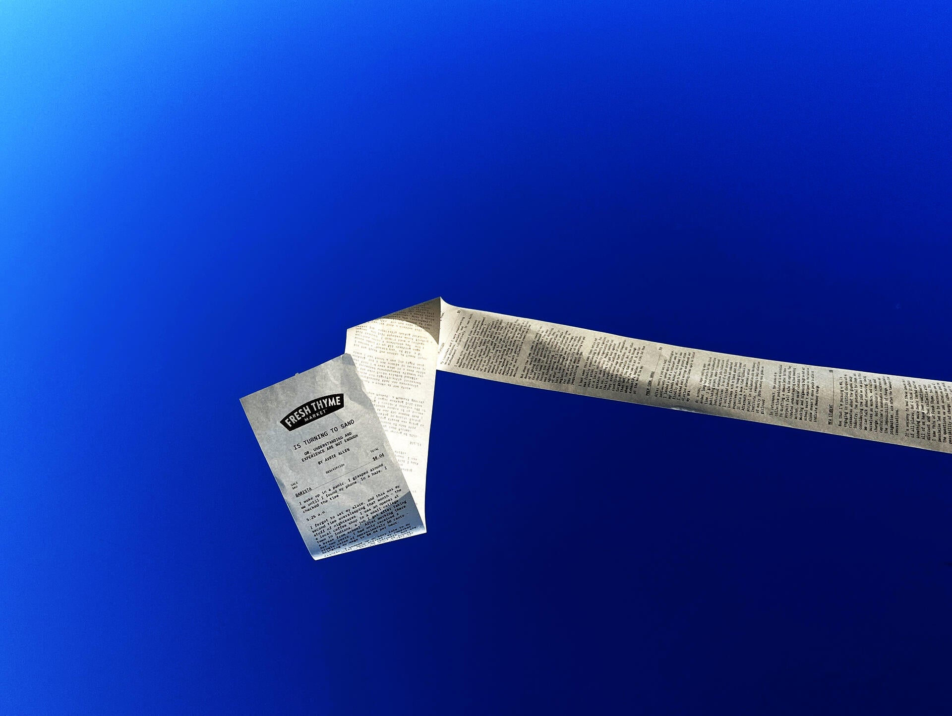 A long receipt used as the form of a publication is blowing in the wind, with blue sky in the background