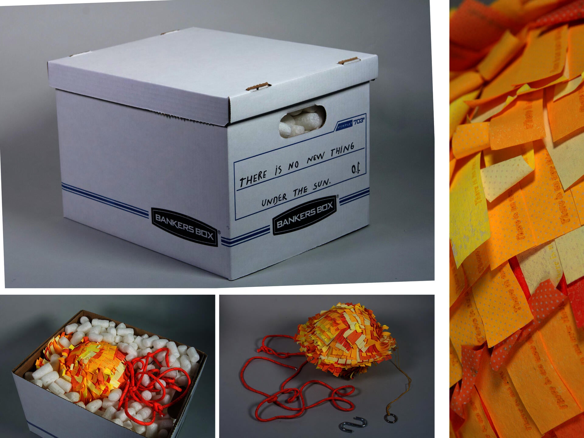 A white cardboard storage box with handwritten text on the side reading ‘THERE IS NO NEW THING UNDER THE SUN’ sits against a gray background. Inside the box are white packing peanuts, a sun-shaped piñata